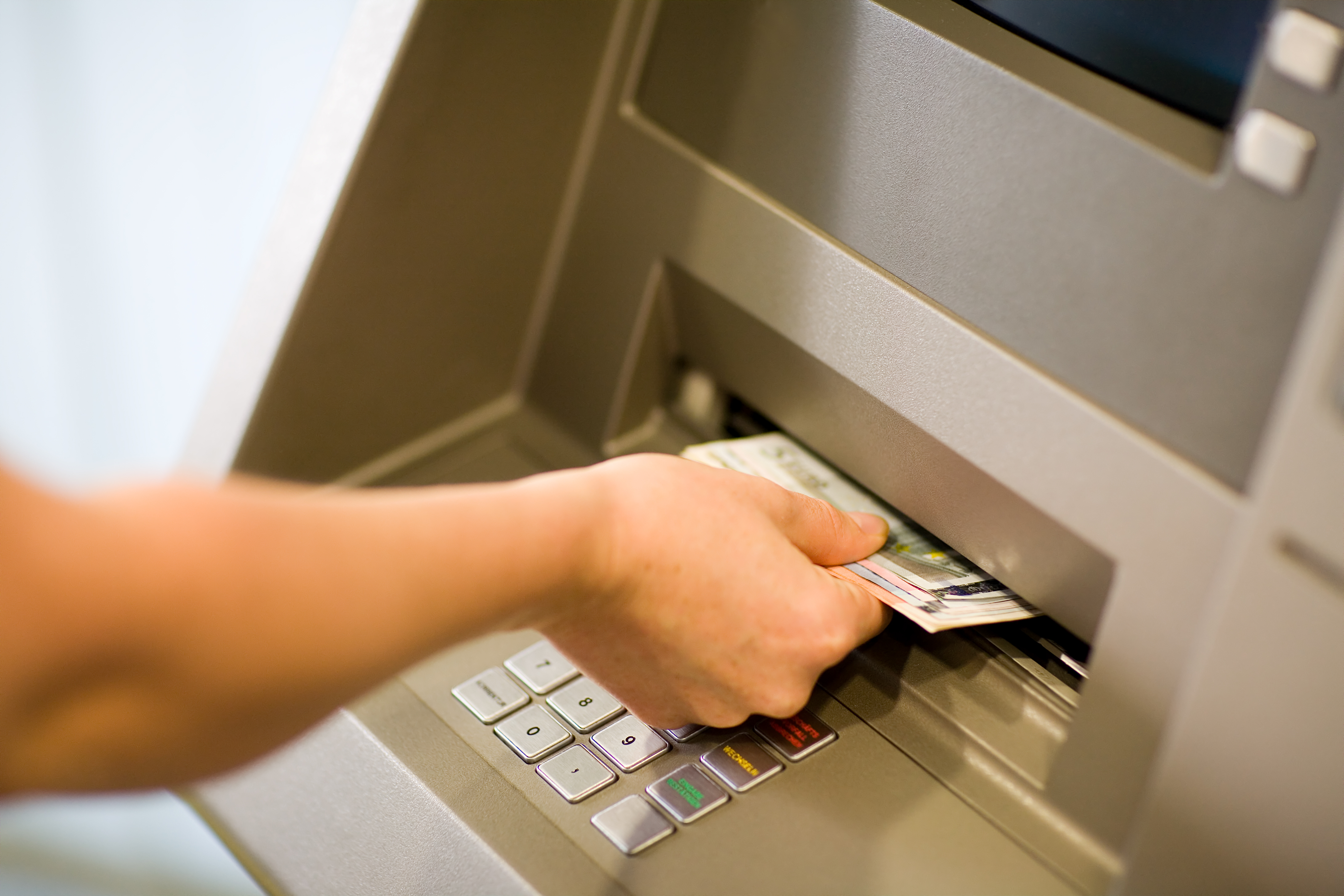 Eine Person, die Geld von einem Geldautomaten abhebt. | Quelle: Shutterstock
