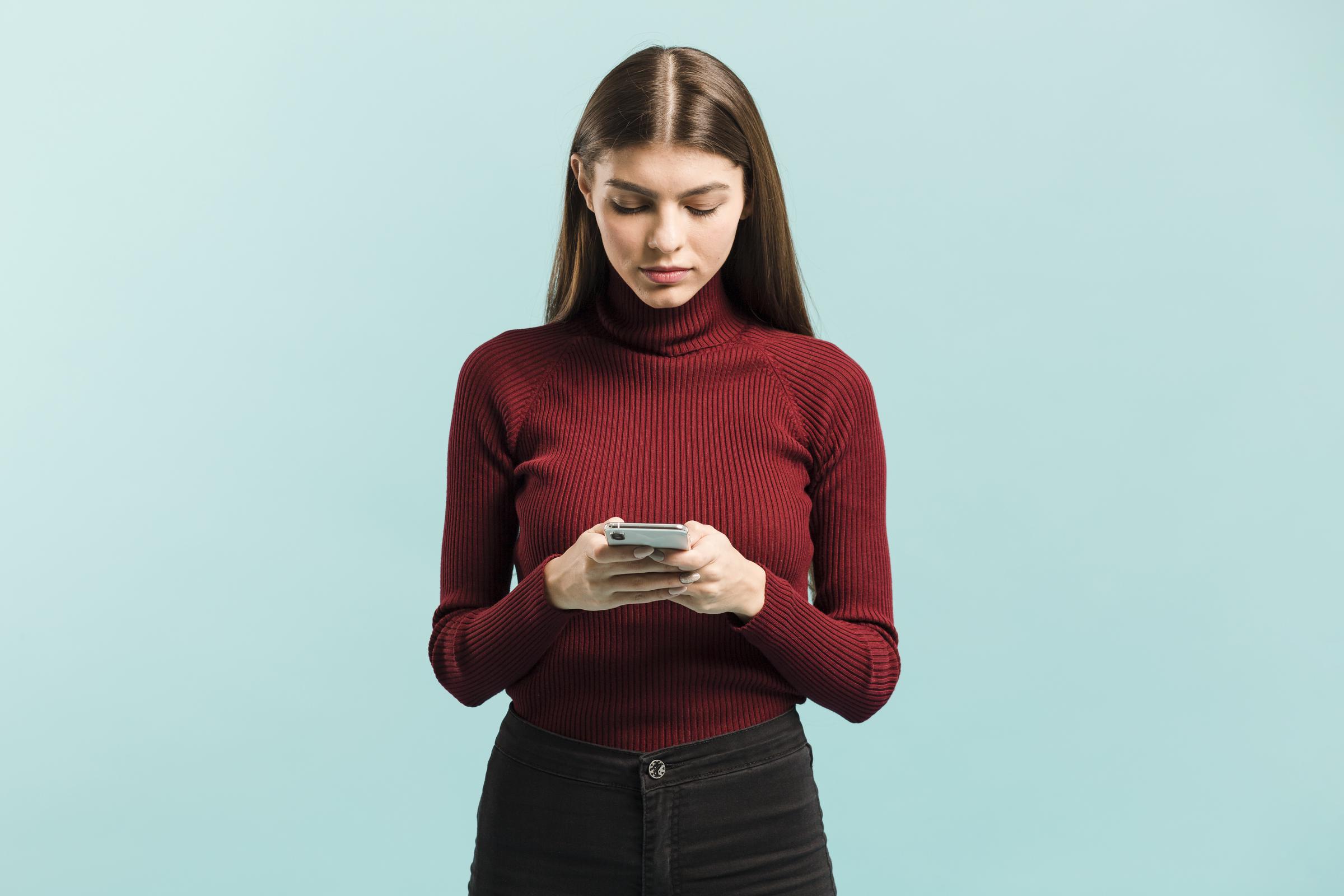 Eine junge Frau benutzt ihr Telefon | Quelle: Freepik