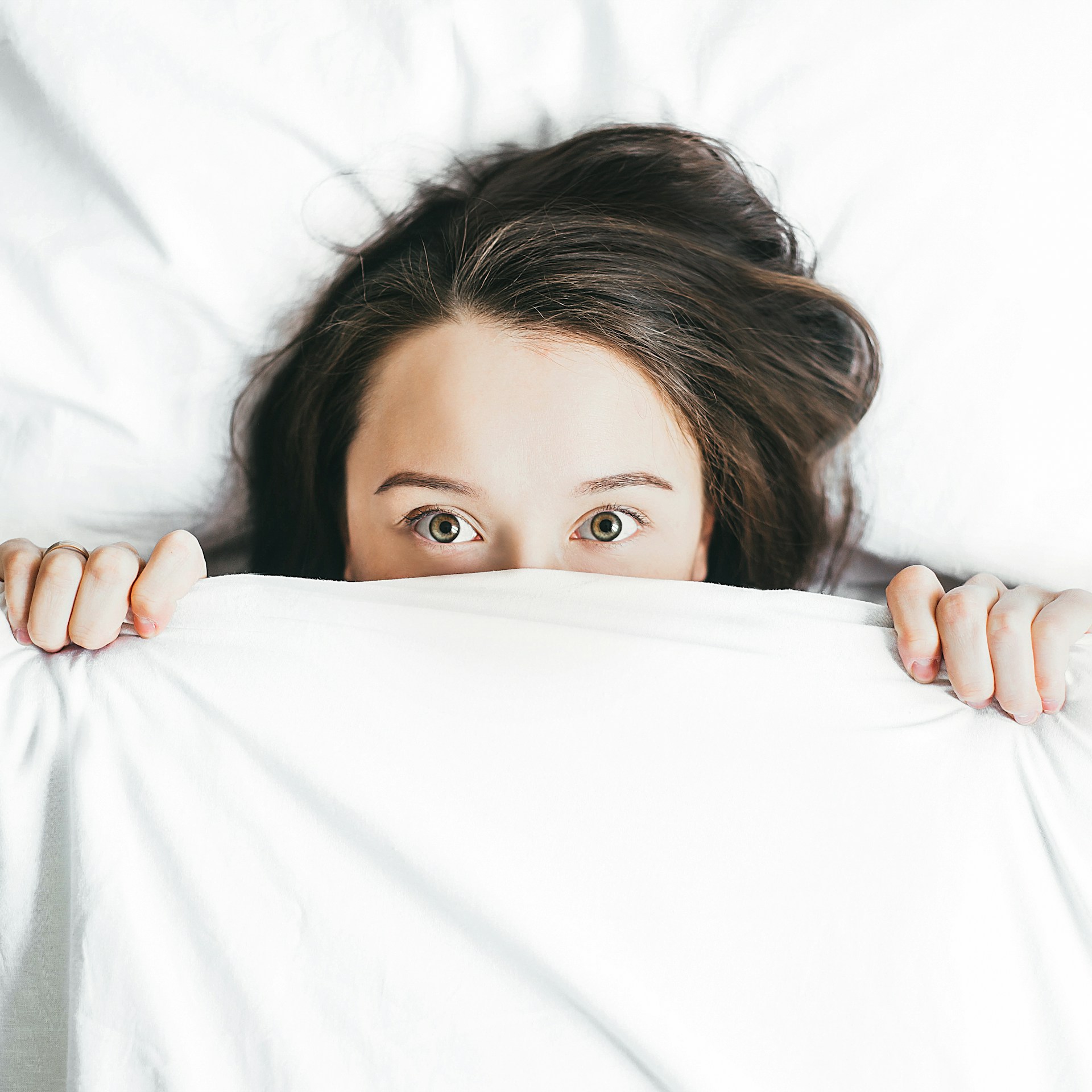 Eine ängstliche Frau liegt im Bett | Quelle: Unsplash