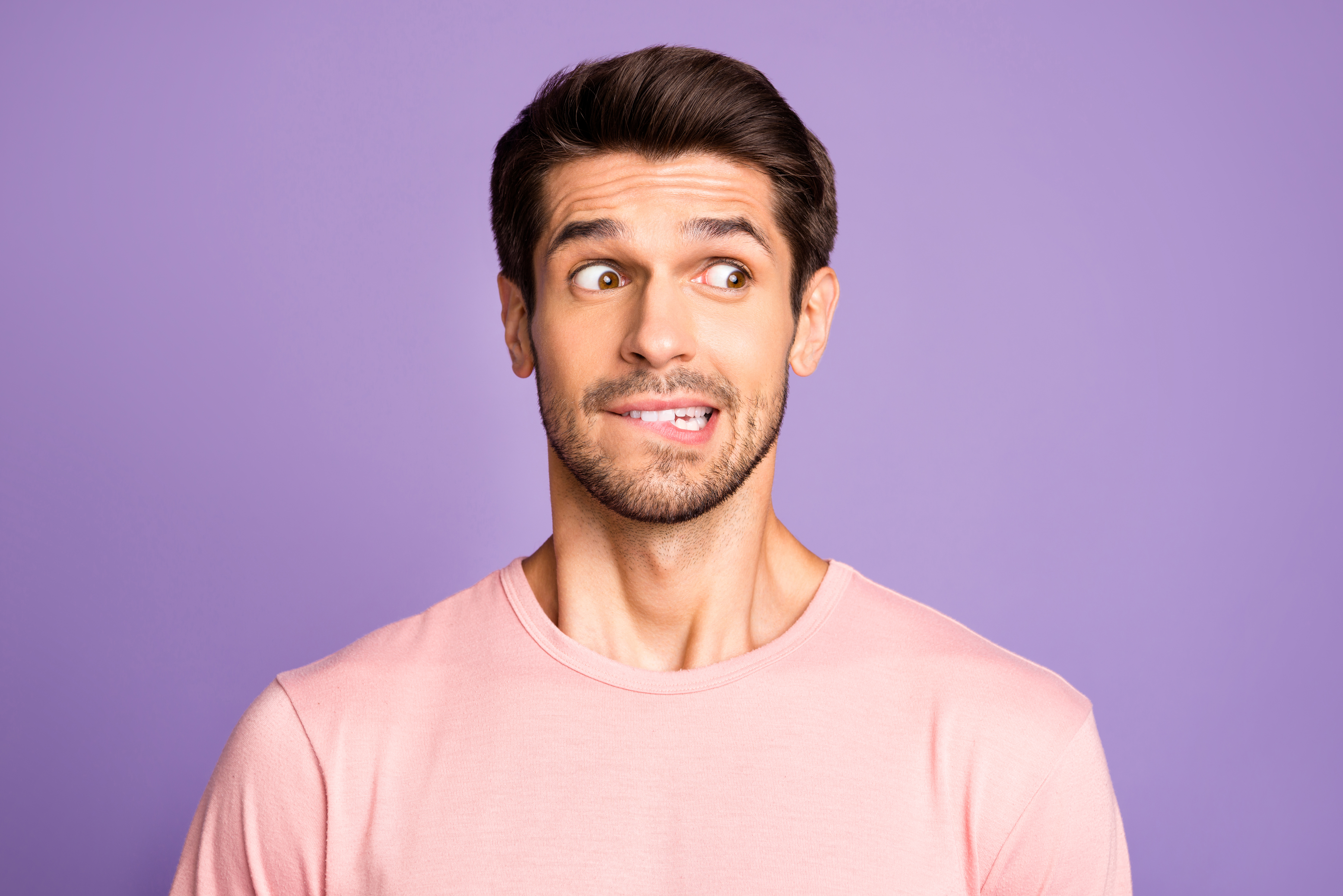 Close-up Porträt von einem bärtigen Mann mit rosa T-Shirt | Quelle: Getty Images