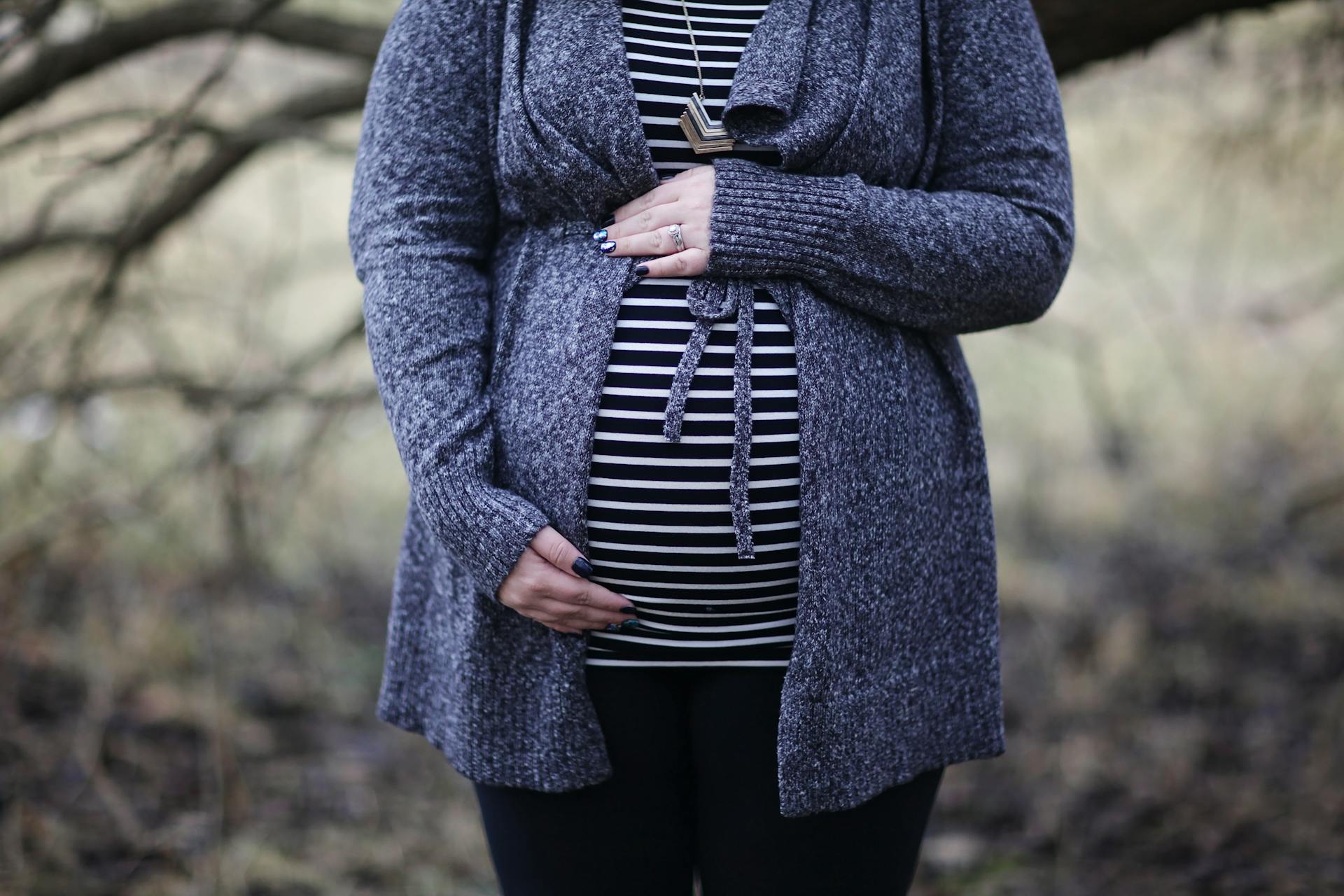 Eine schwangere Frau, die ihren Babybauch hält | Quelle: Pexels