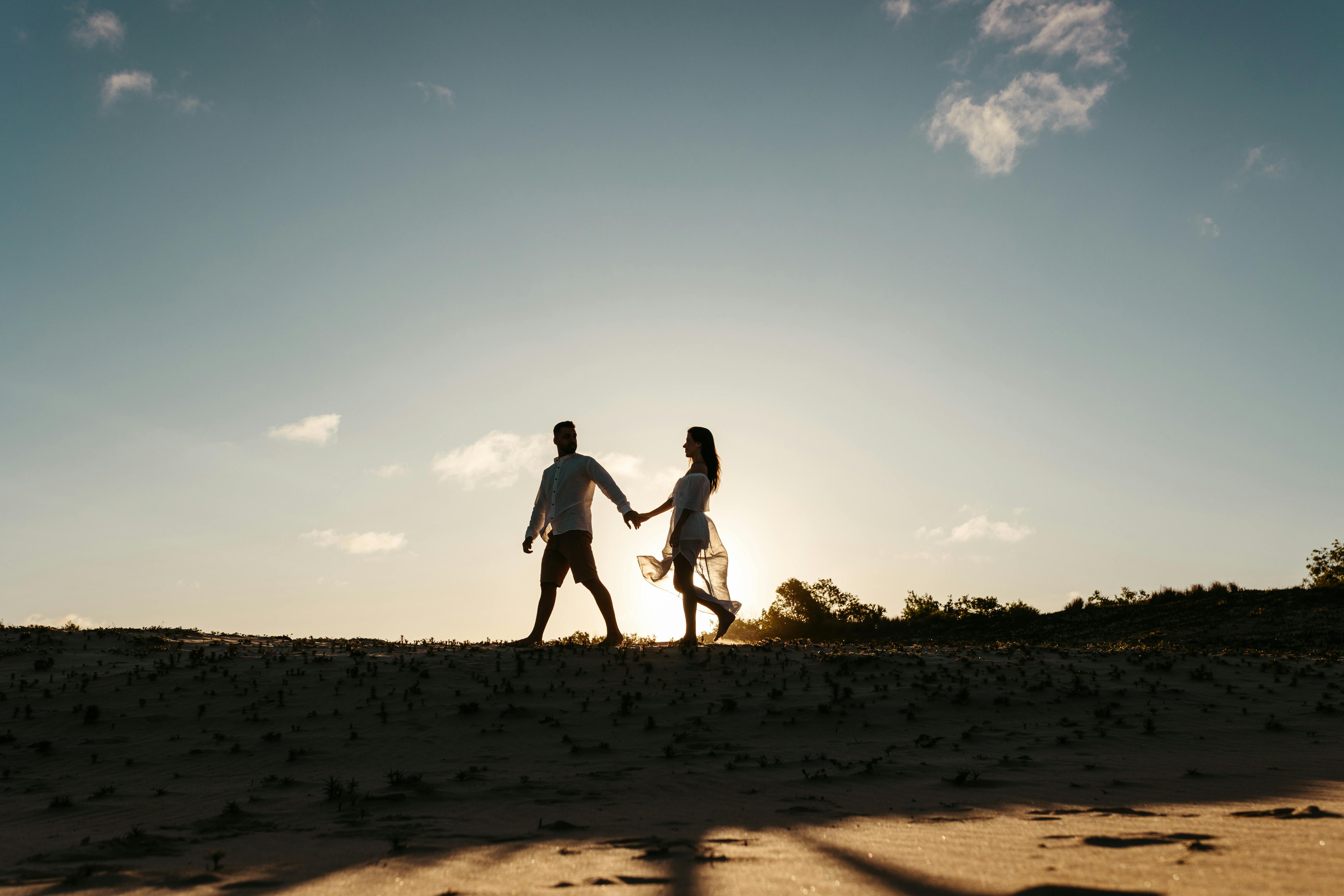 Mann und Frau gehen Hand in Hand im Freien | Quelle: Pexels