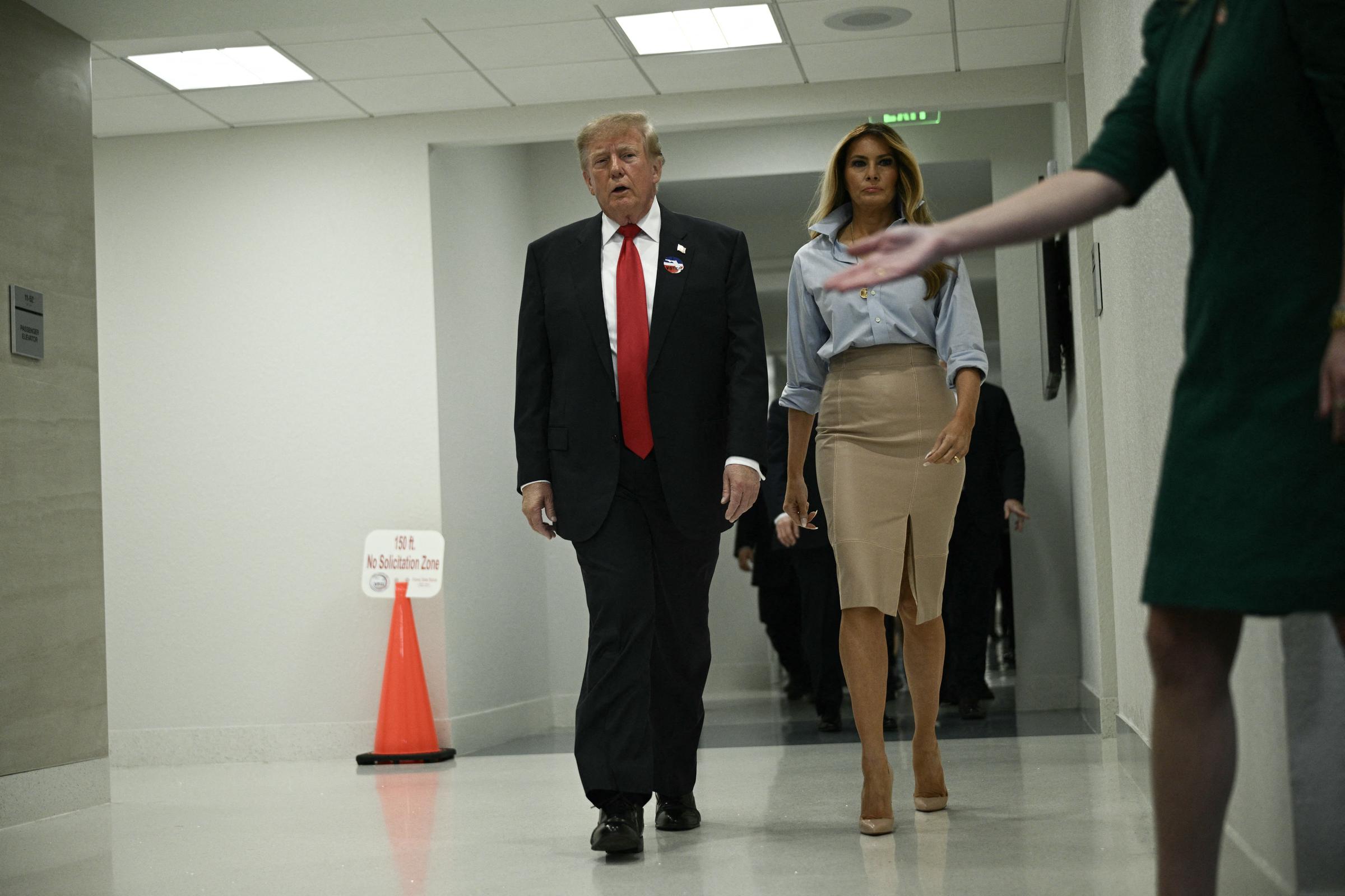 Als sie nach der Stimmabgabe einen Flur im Inneren entlanggehen, zieht die First Lady in ihrem Oberteil mit Kragen und hochgekrempelten Ärmeln sowie ihrem Rock mit Schlitz vorne alle Blicke auf sich. Sie rundet die entspannte Farbpalette mit schwindelerregend hohen nudefarbenen Stilettos ab, die jedem Schritt eine gewagte, messerscharfe Note verleihen.