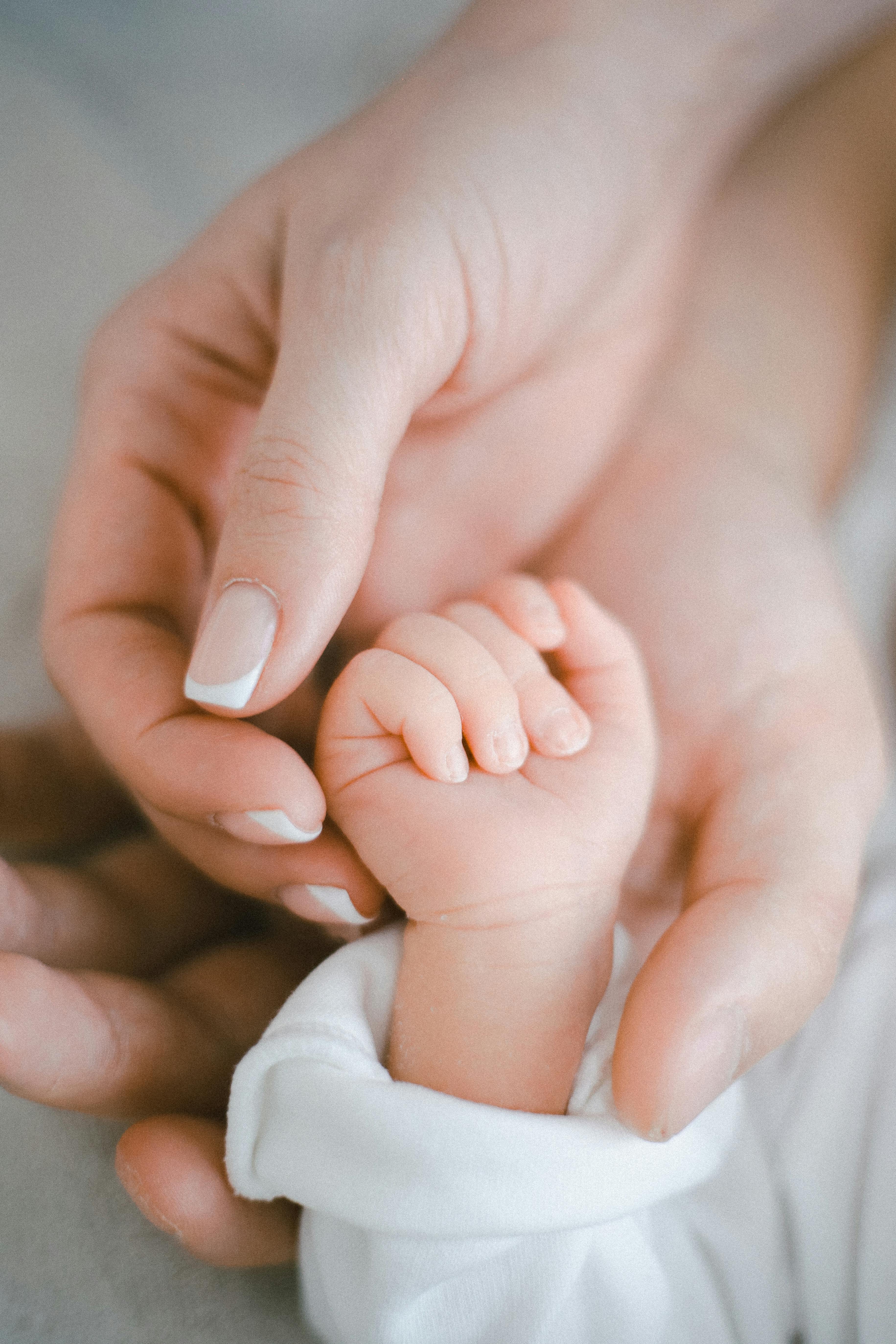 Die Hände der Eltern, die ihr Kind halten | Quelle: Pexels