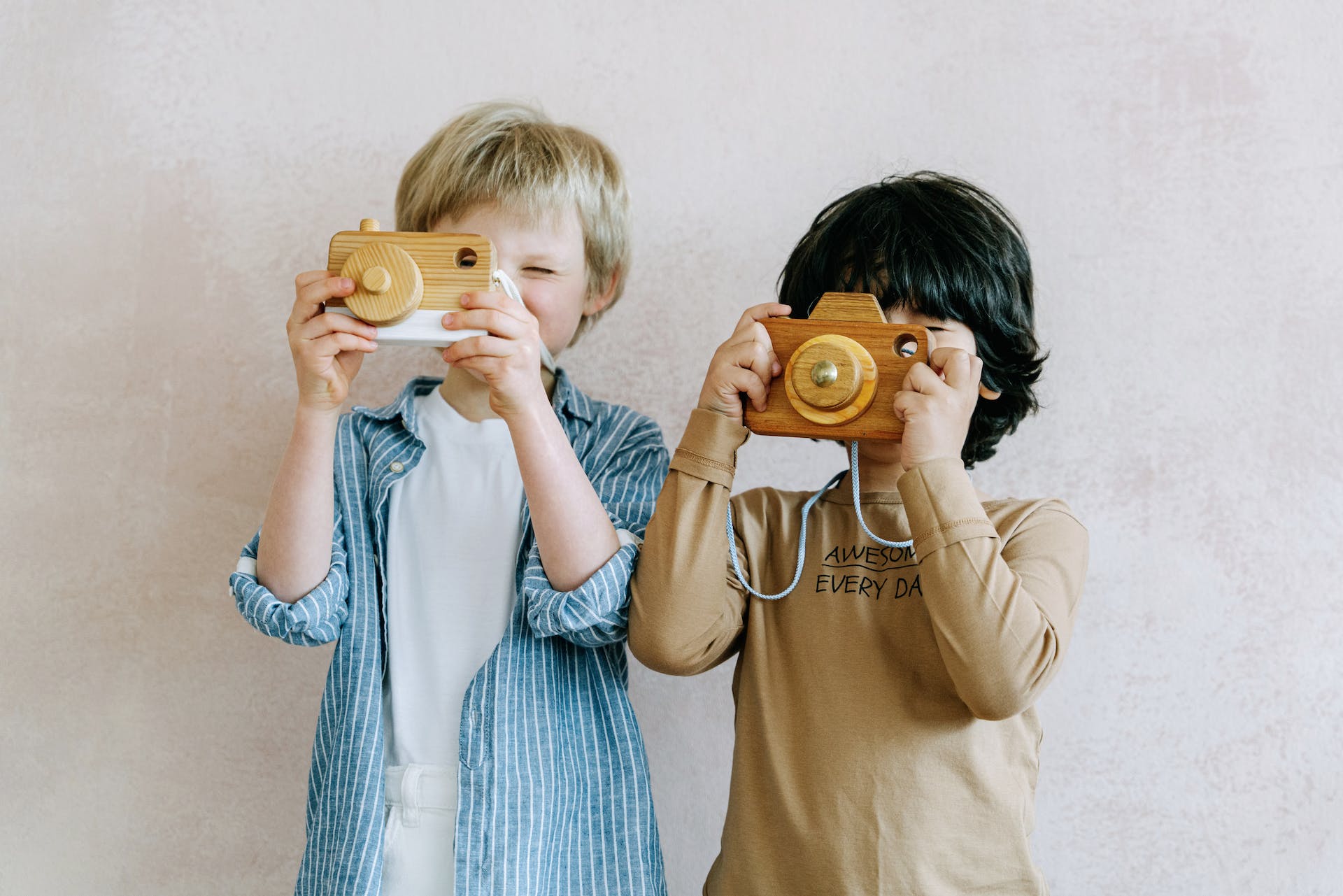 Zwei Jungen spielen mit einer Spielzeugkamera | Quelle: Pexels