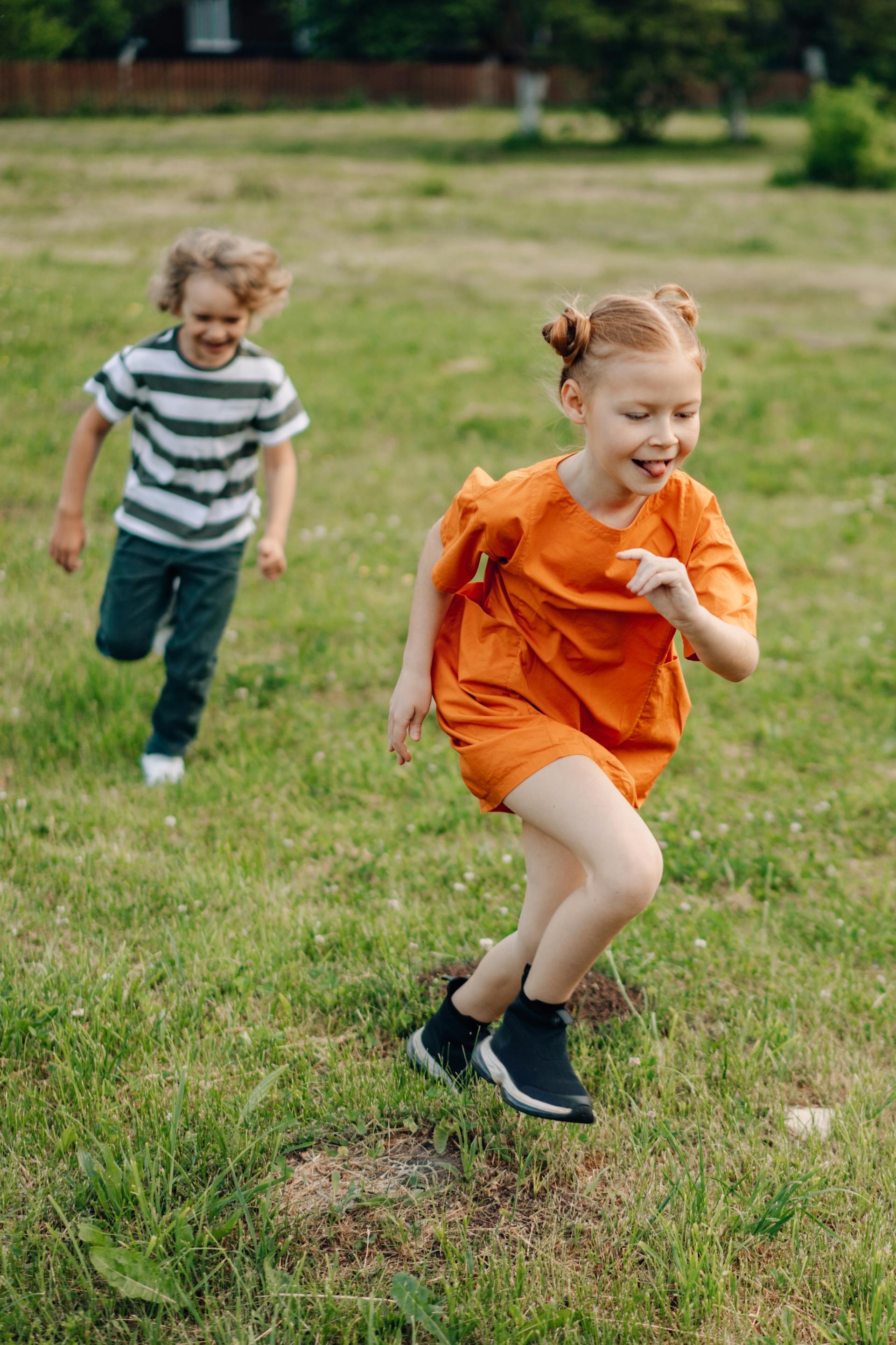 Junge und Mädchen laufen auf Gras | Quelle: Pexels
