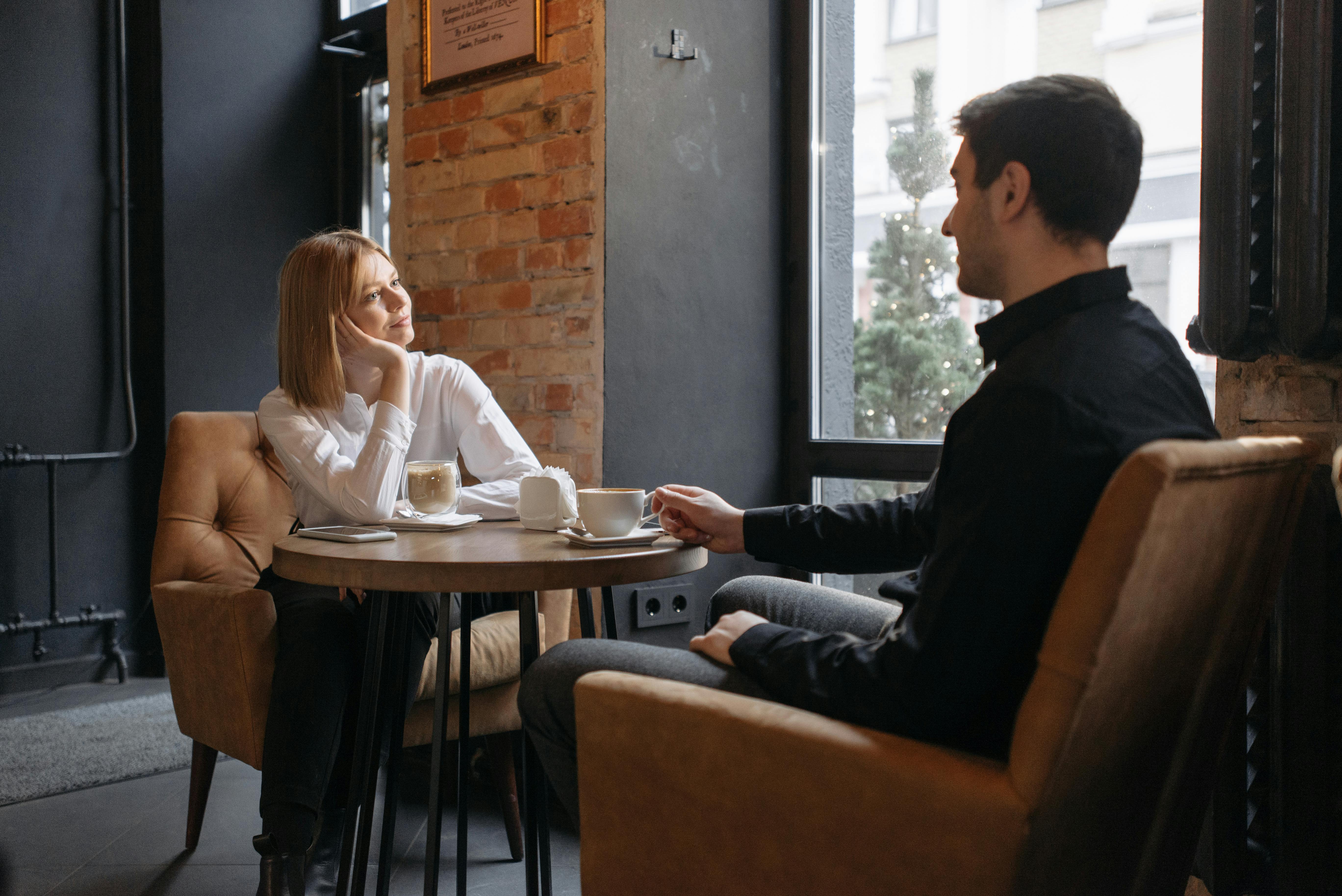 Ein Mann und eine Frau unterhalten sich in einem Cafe | Quelle: Pexels