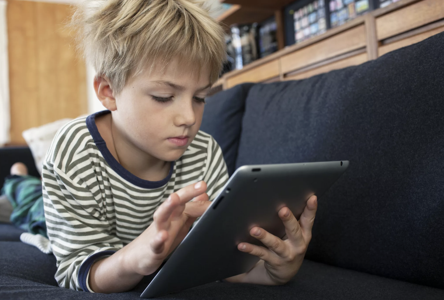 Junge vertieft in ein Tablet | Quelle: Shutterstock