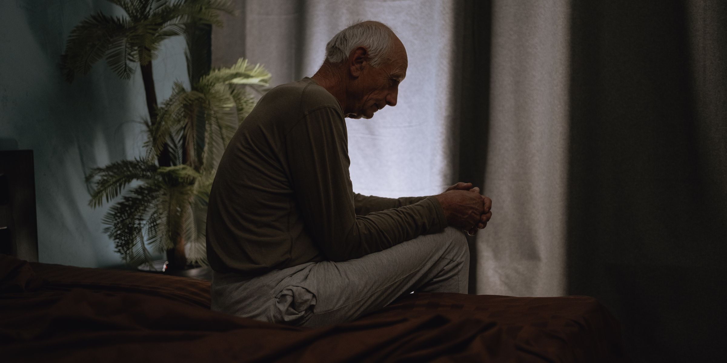 Ein alter, unglücklicher Mann, der alleine sitzt | Quelle: Shutterstock