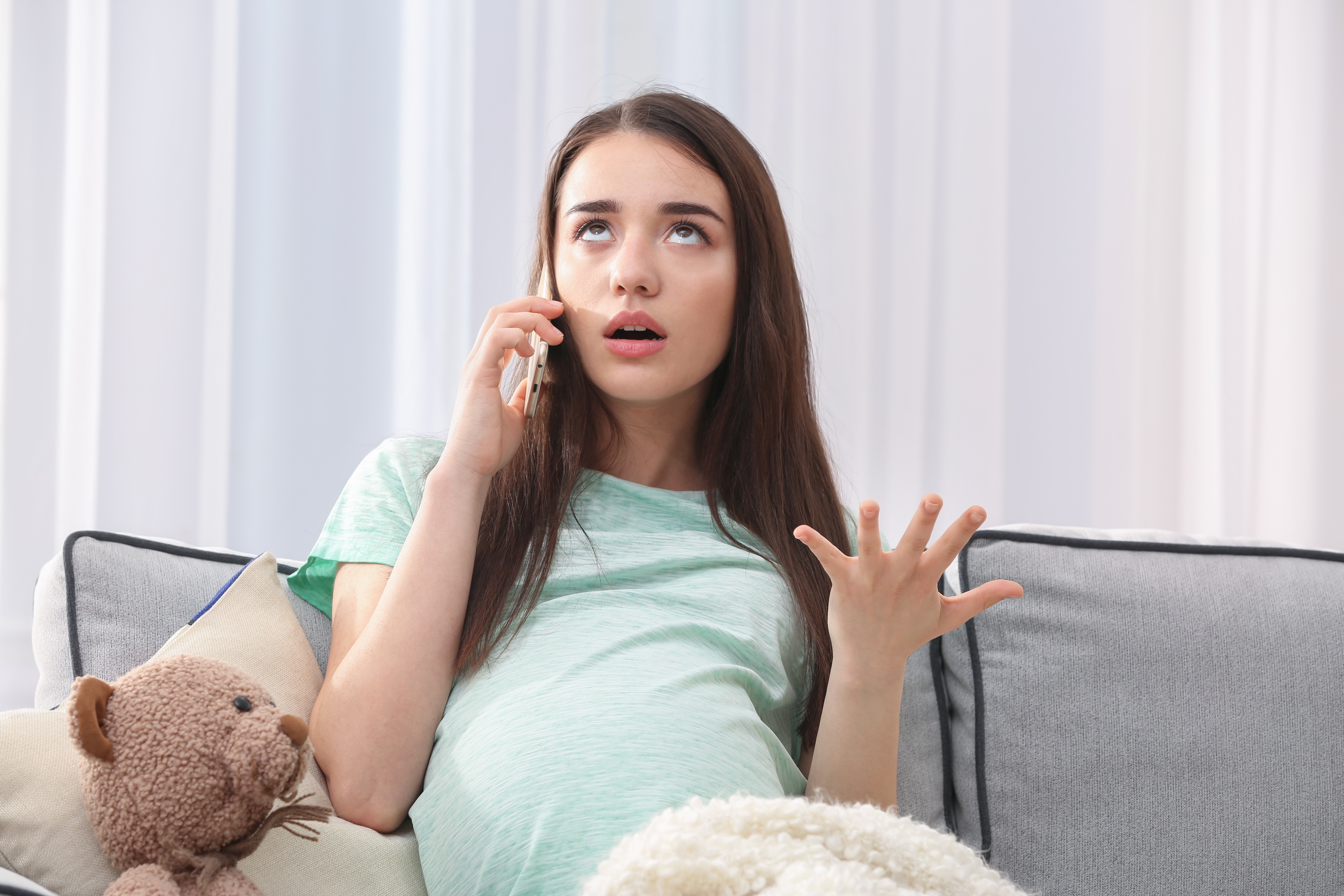 Eine schwangere Frau schaut genervt, während sie telefoniert | Quelle: Shutterstock