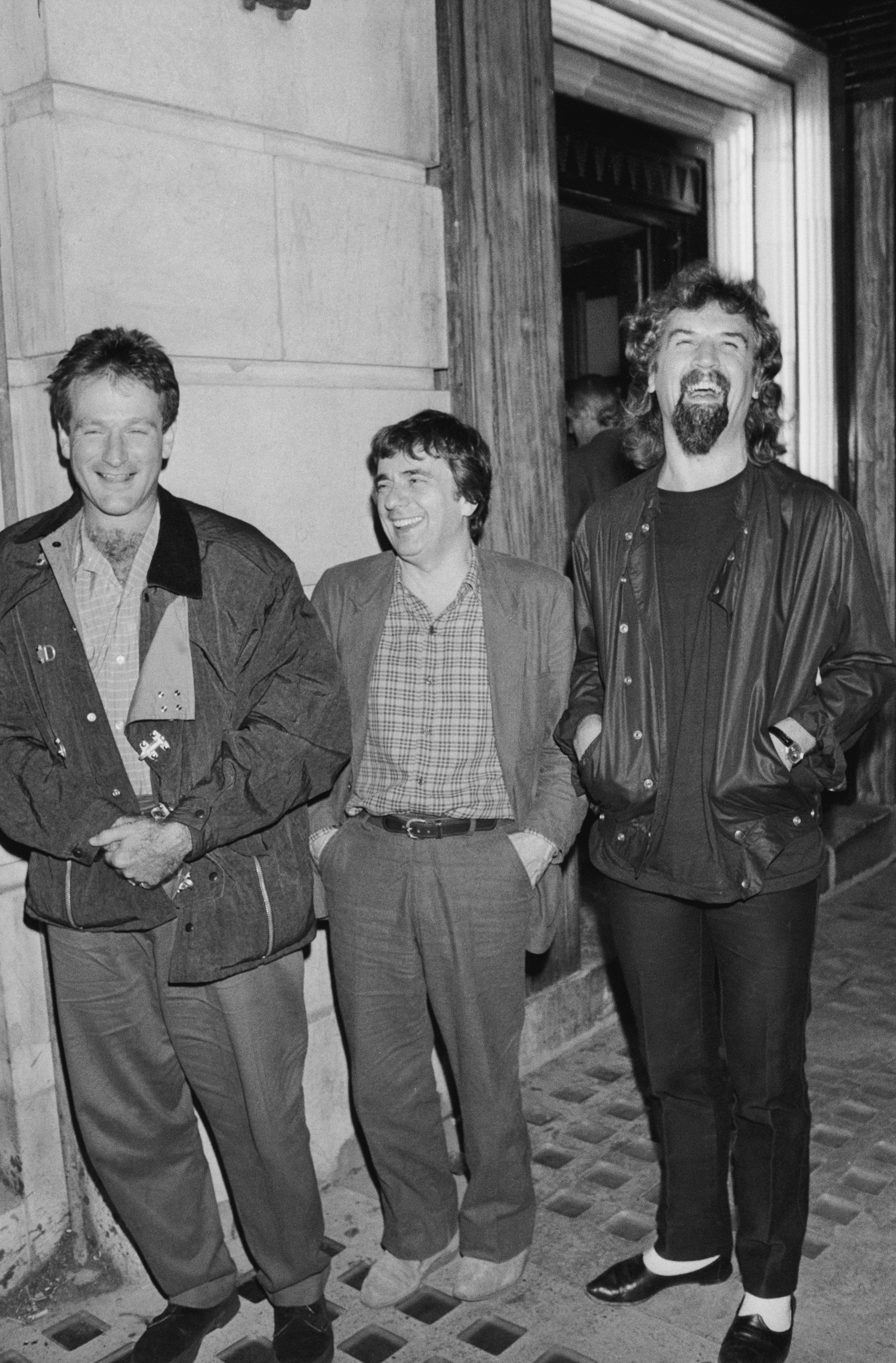 (L-R) Robin Williams, Dudley Moore und Billy Connolly, fotografiert vor dem Restaurant Langan's am 1. Januar 1985 in London, England. | Quelle: Getty Images