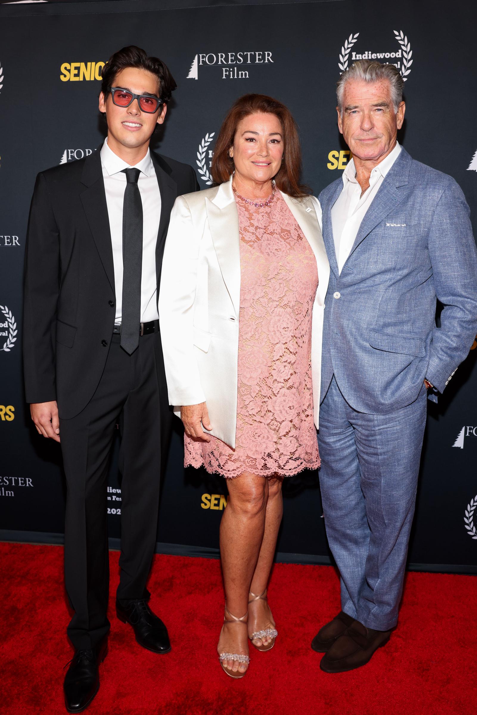 Pierce Brosnan und Keely Shaye Smith posierten stolz mit ihrem Sohn Paris – Keely trug ein rosa Spitzenkleid und Pierce einen hellblauen Anzug –, was die enge Verbundenheit der Familie unterstrich. | Quelle: Getty Images.