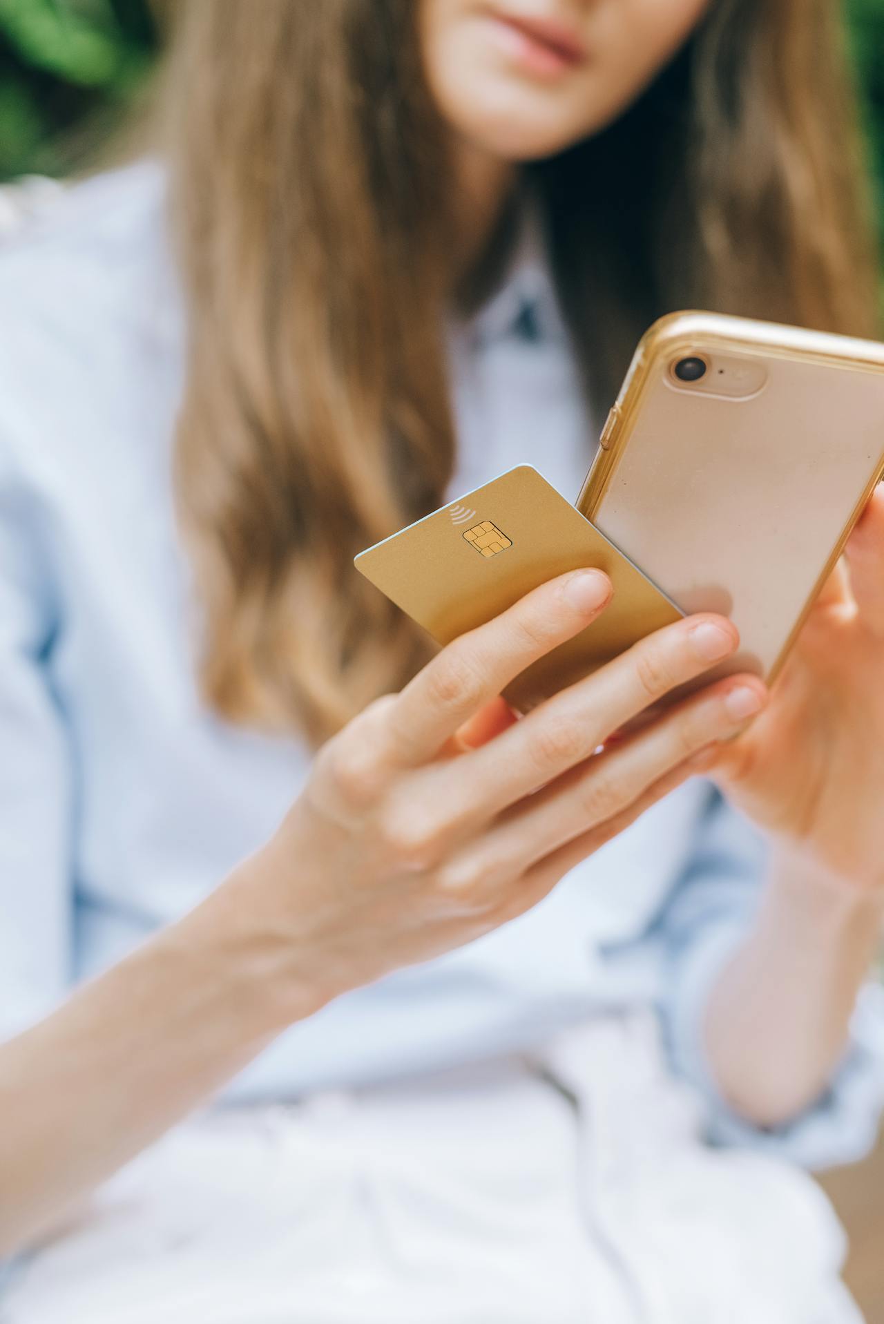 Eine junge Frau hält ihr Telefon und ihre Kreditkarte in der Hand | Quelle: Pexels