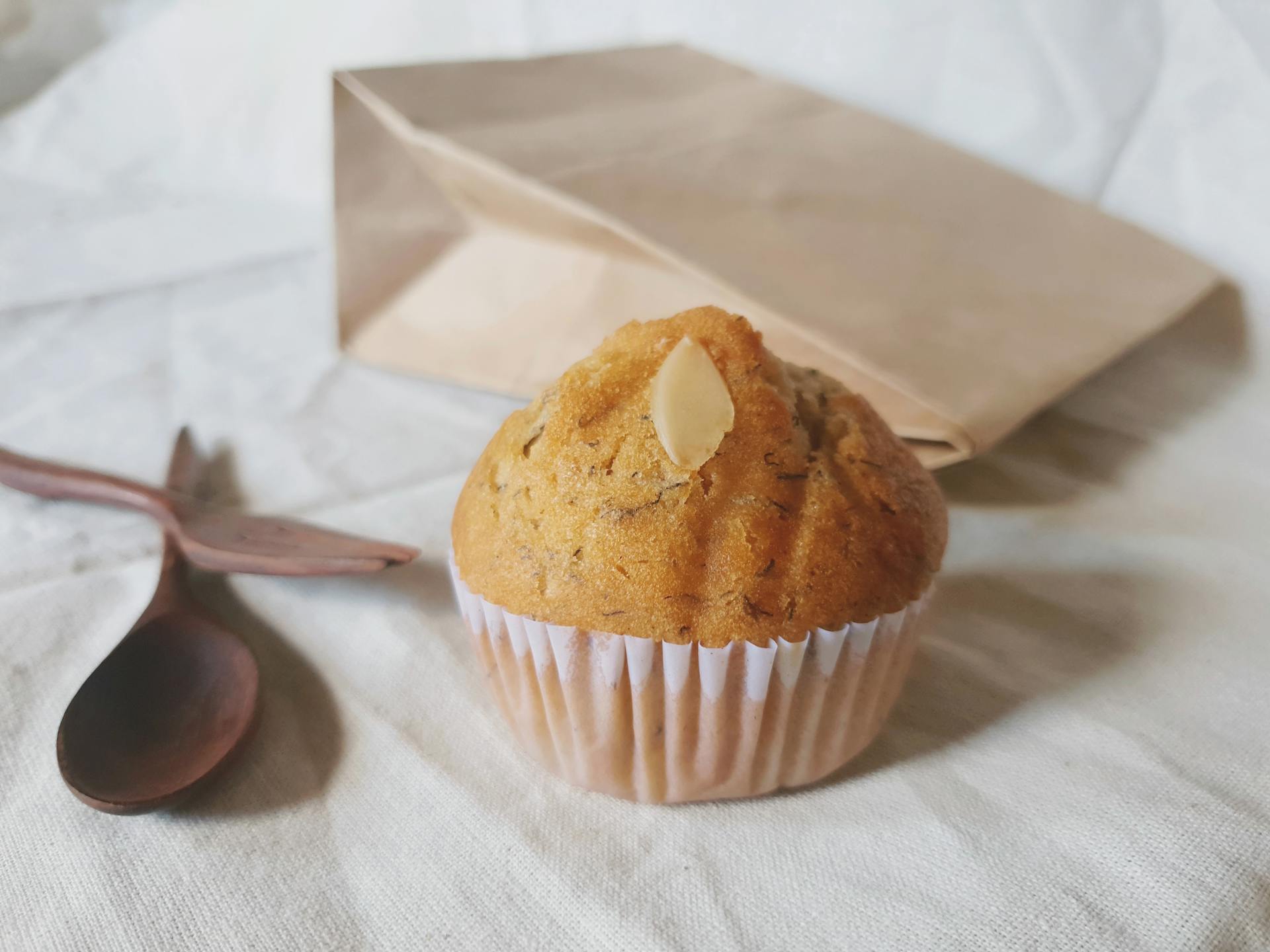 Ein Muffin und eine braune Papiertüte | Quelle: Pexels