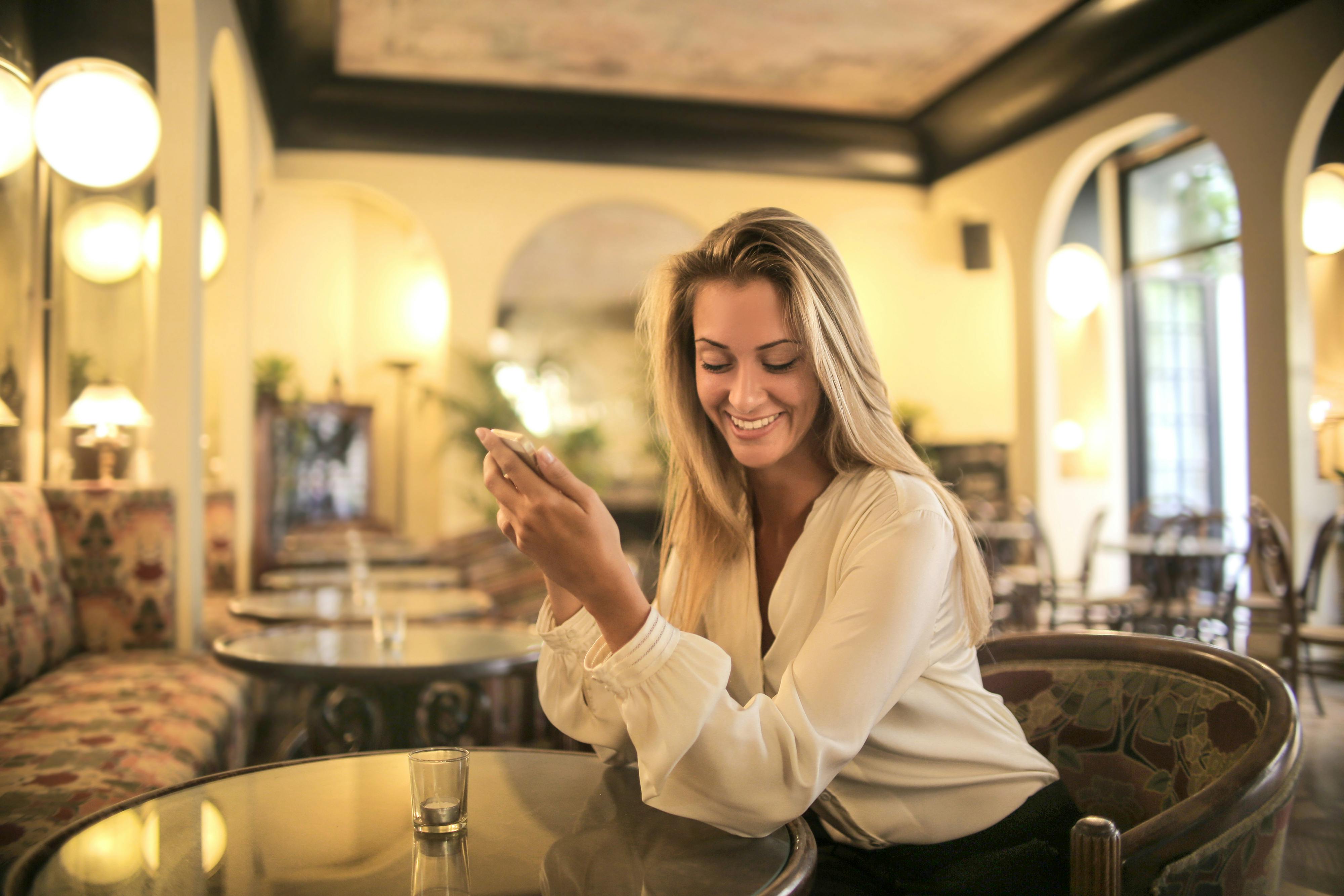 Eine scheinbar glückliche Frau, die ihr Telefon hochhält | Quelle: Pexels