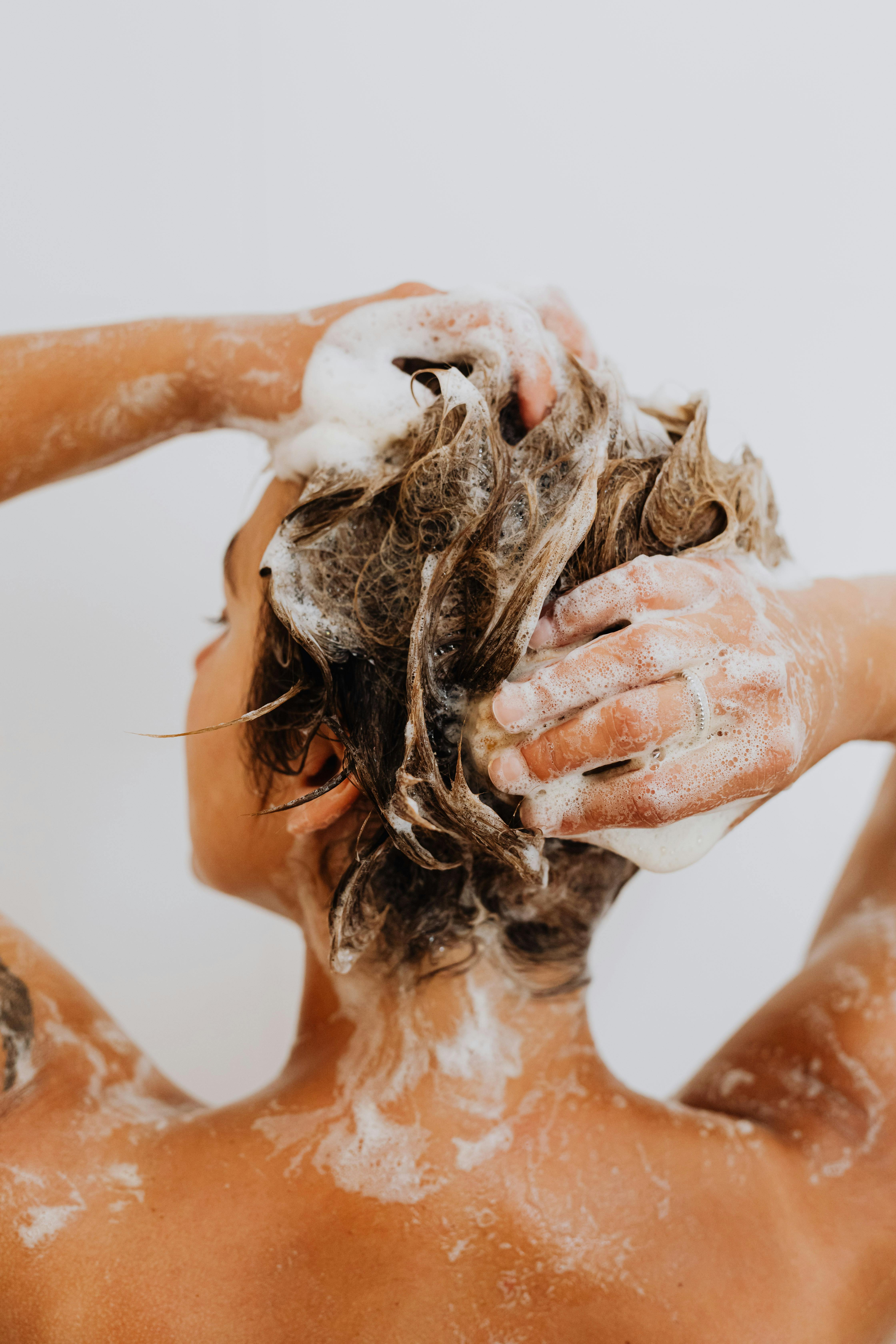Eine Frau wäscht sich die Haare unter der Dusche | Quelle: Pexels