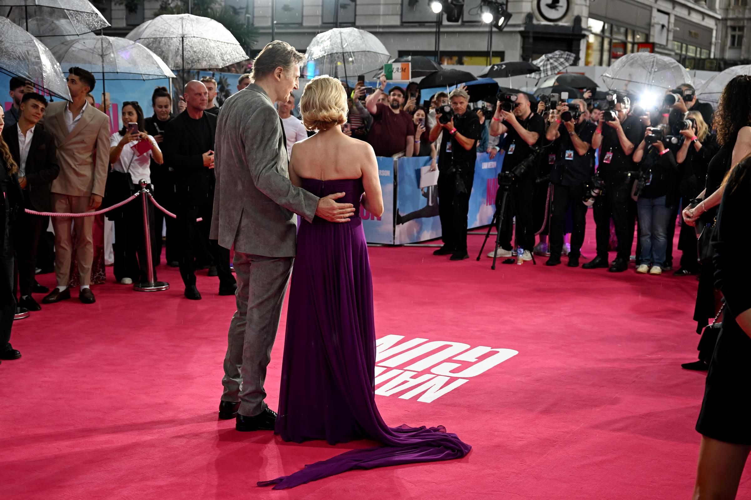 Liam Neeson hält Pamela Anderson an der Taille, während die beiden bei der britischen Premiere von „Die nackte Kanone“ im Cineworld Leicester Square in London, England, am 22. Juli 2025 Fotos machen | Quelle: Getty Images
