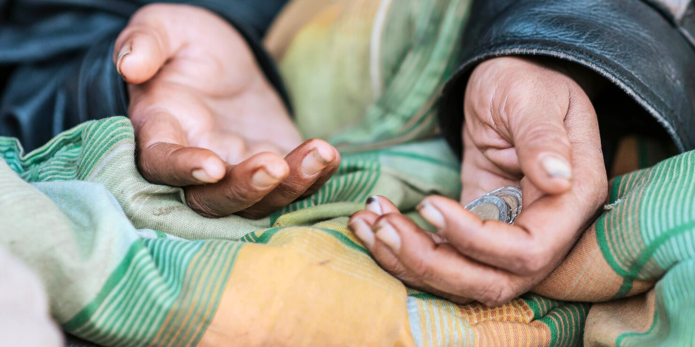 Münzen in der Hand einer obdachlosen Frau | Quelle: Freepik