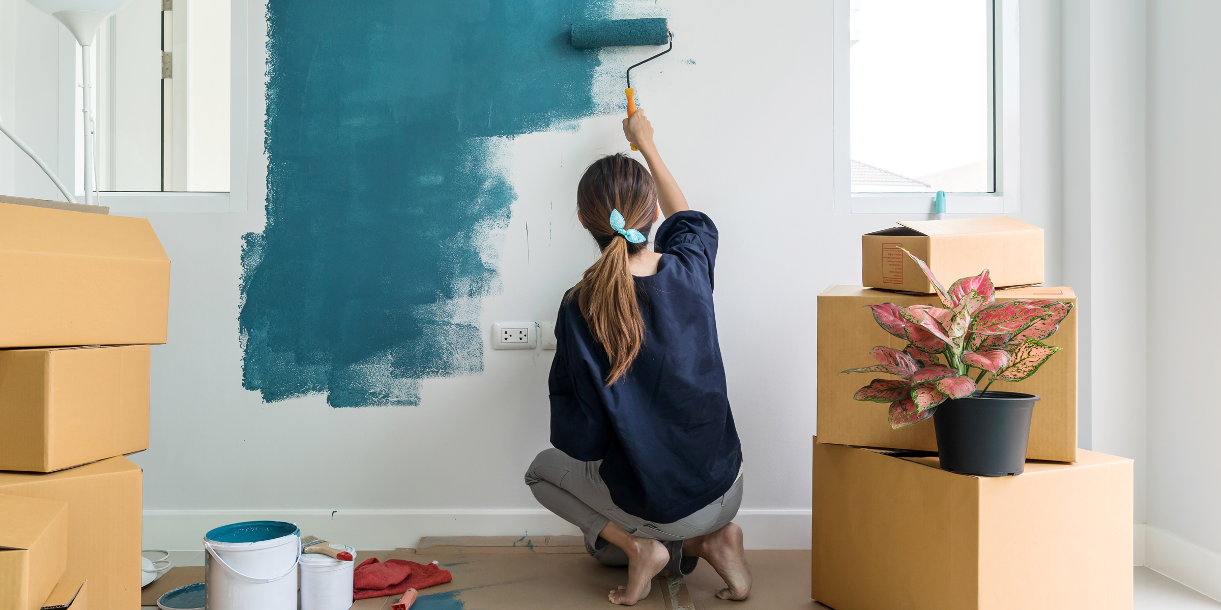 Eine Frau streicht eine Wand | Quelle: Shutterstock