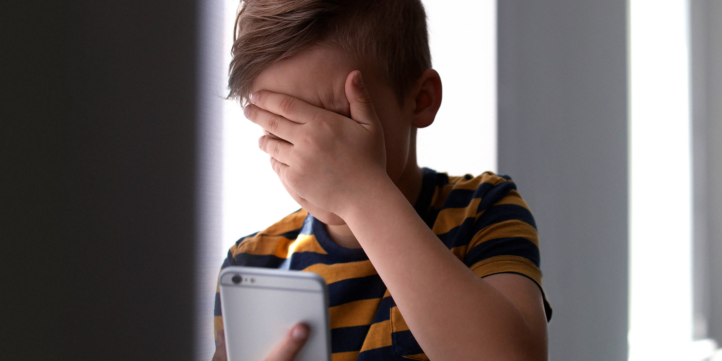 Weinender Junge beim Telefonieren | Quelle: Shutterstock