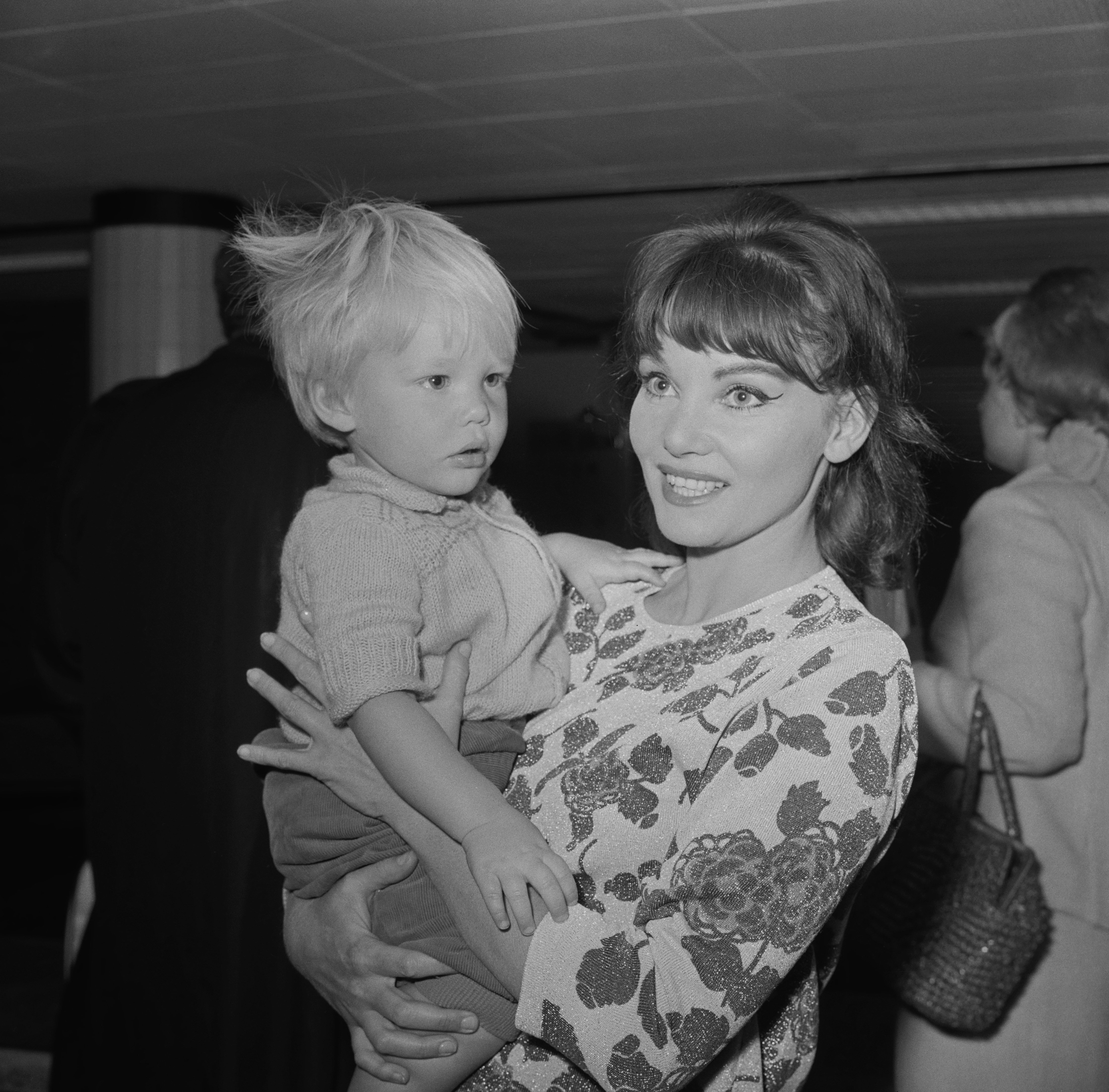 Diane Cilento und Jason am Londoner Flughafen am 15. Juni 1964 | Quelle: Getty Images