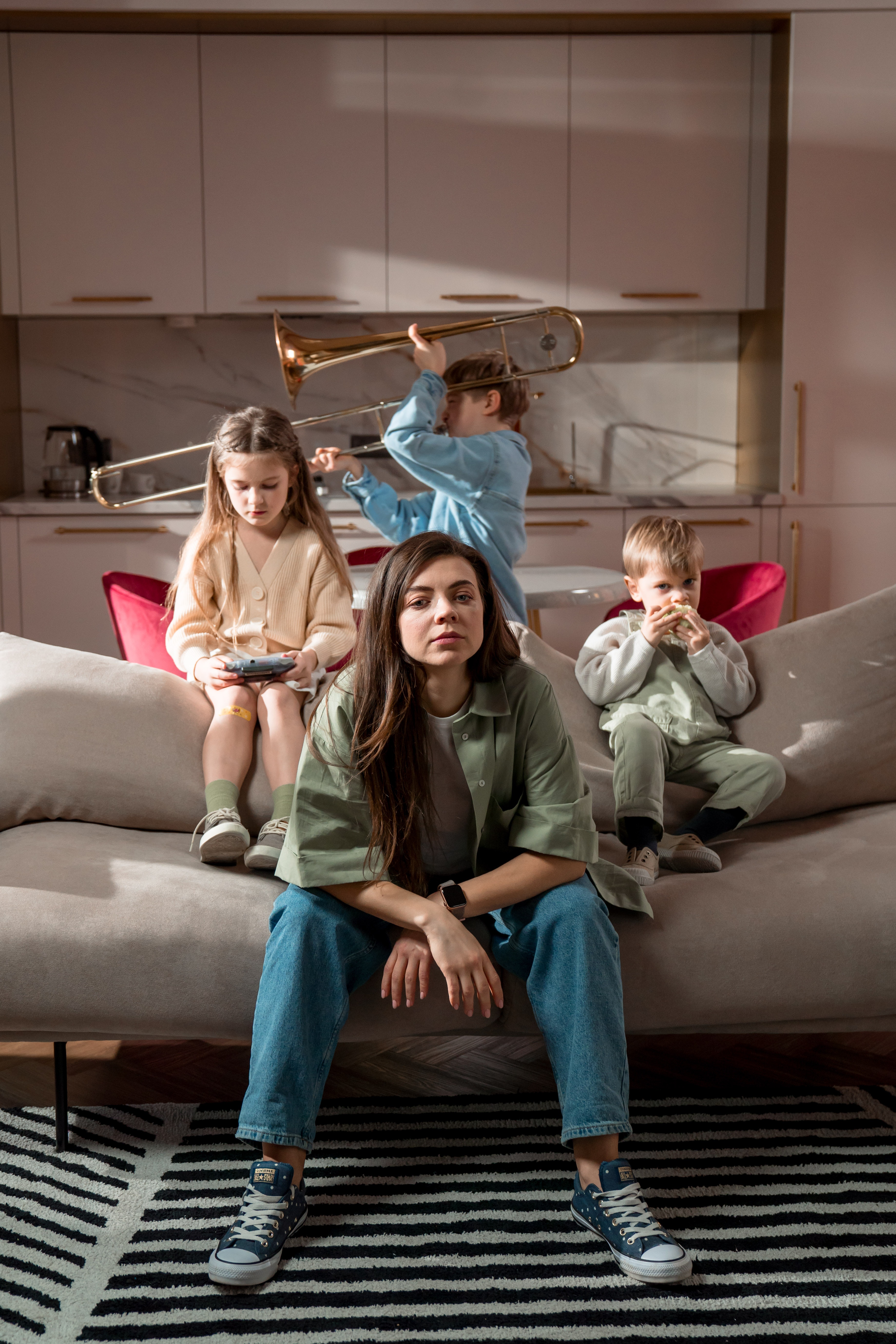 Eine Frau und drei Kinder in einem Wohnzimmer | Quelle: Pexels