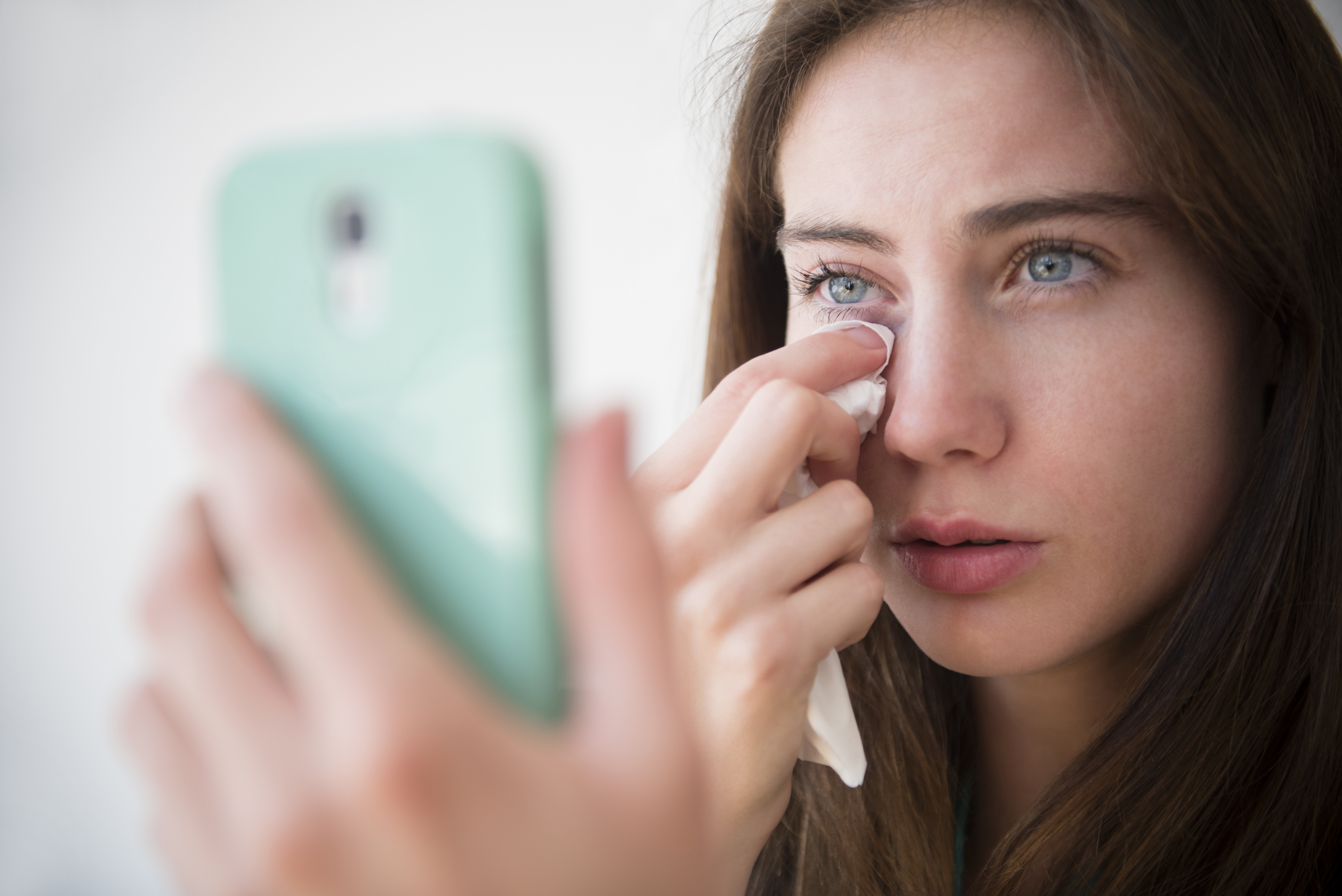 Eine Frau wischt sich während eines Telefonats die Tränen weg | Quelle: Getty Images