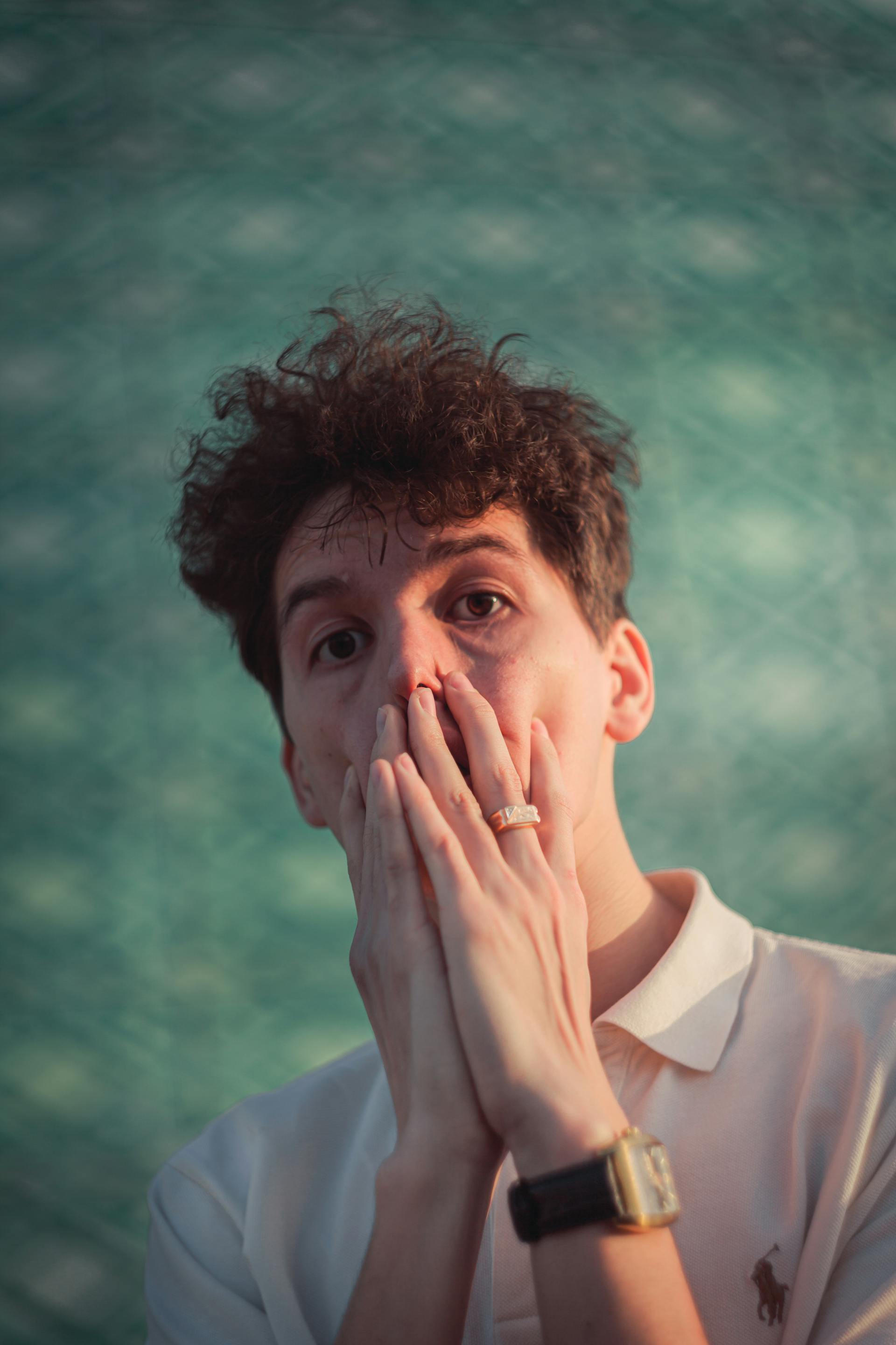 Ein Mann, der seinen Mund mit beiden Händen bedeckt | Quelle: Pexels
