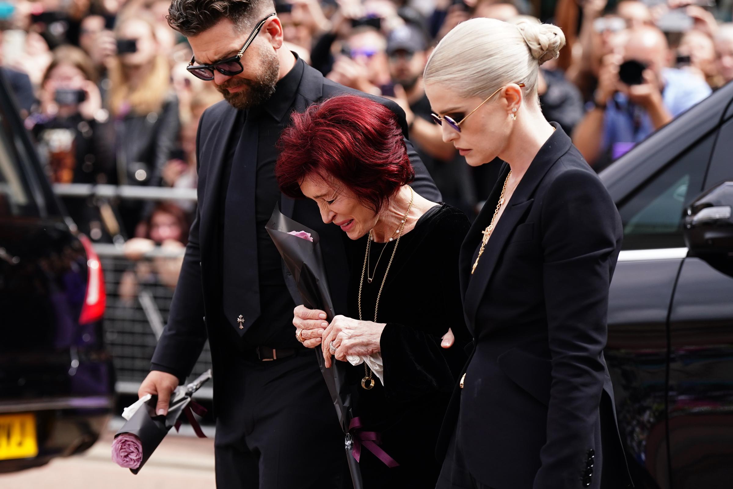 Sharon, Jack und Kelly legen am 30. Juli 2025 Blumen an der Black Sabbath Bridge in der Broad Street in Birmingham nieder | Quelle: Getty Images