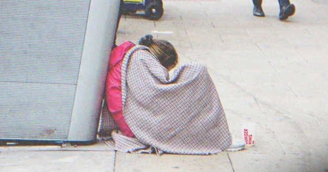Bettelnde Frau, die auf der Straße sitzt | Quelle: Shutterstock