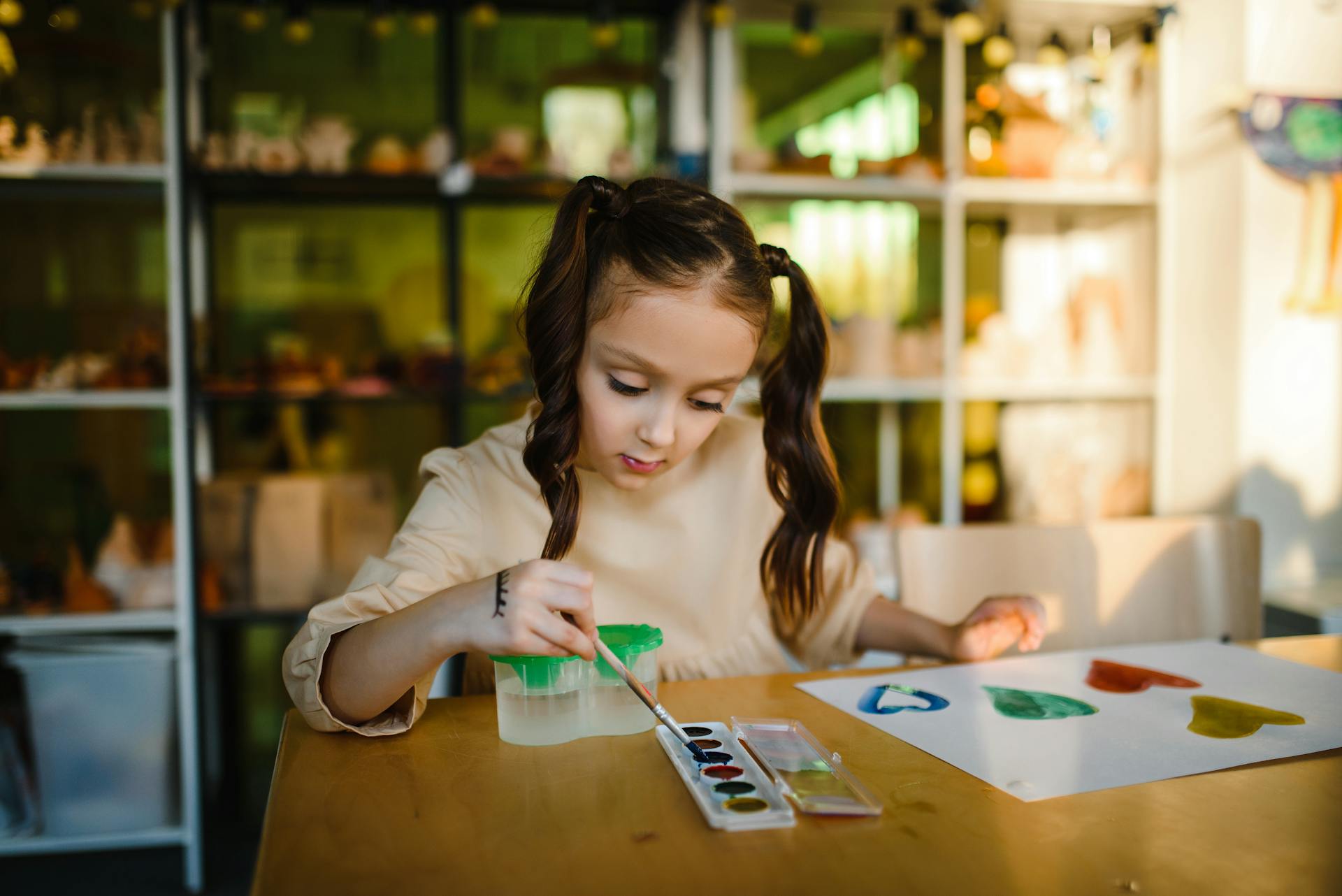 Uma menina pinta um quadro em um papel | Fonte: Pexels