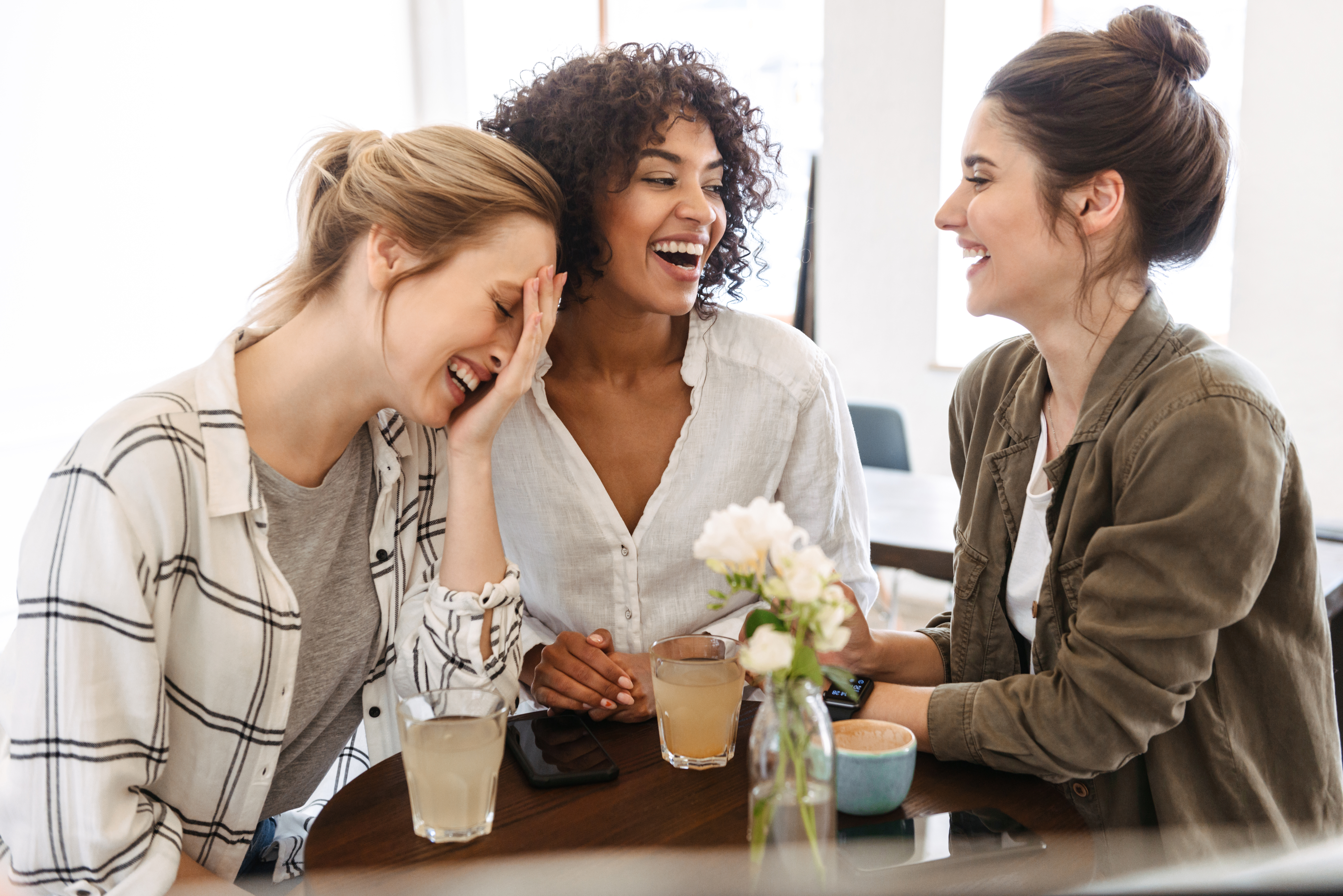 Drei glückliche Frauen, die Kaffee und Getränke genießen | Quelle: Shutterstock