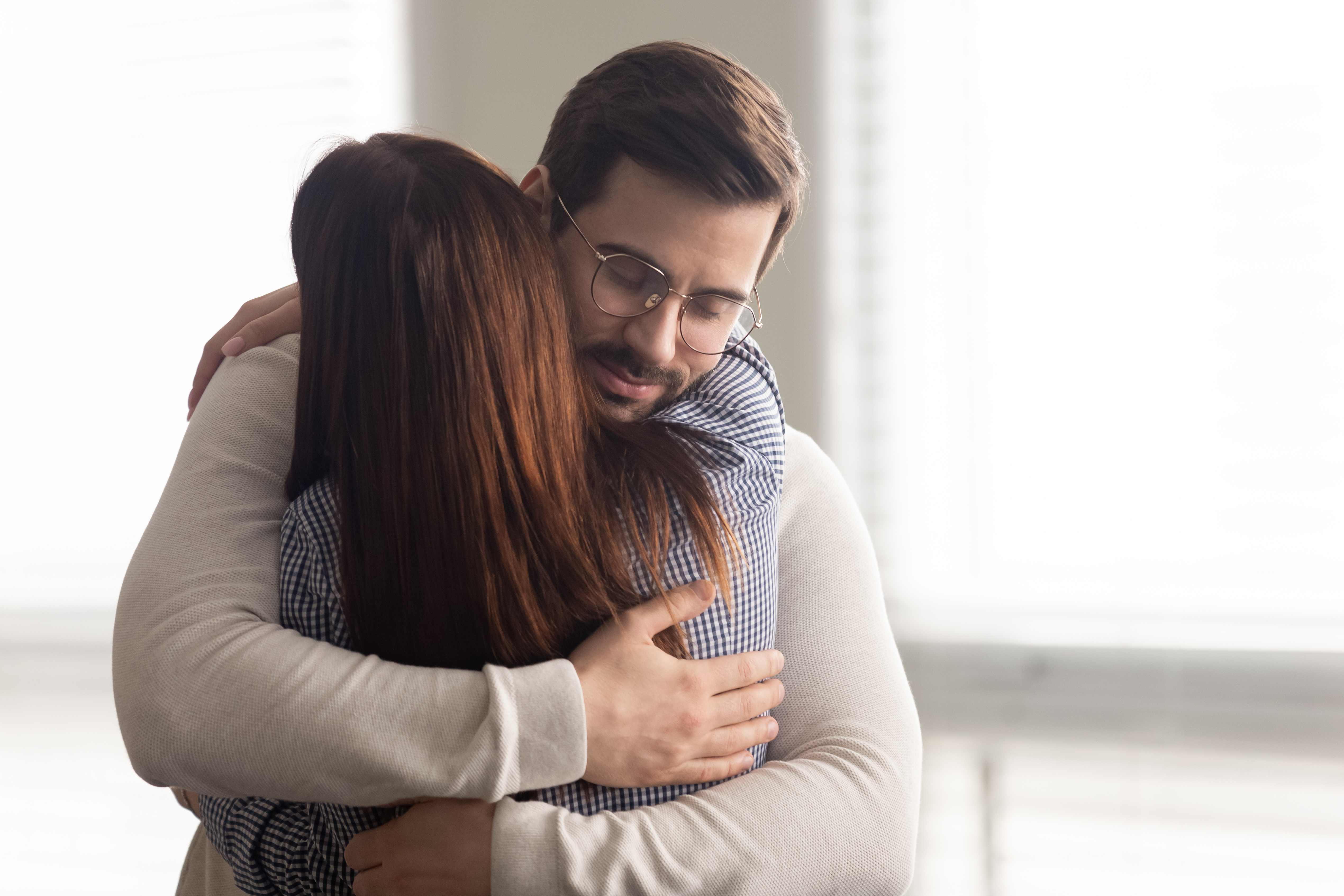Ein junger Mann umarmt eine Frau | Quelle: Shutterstock