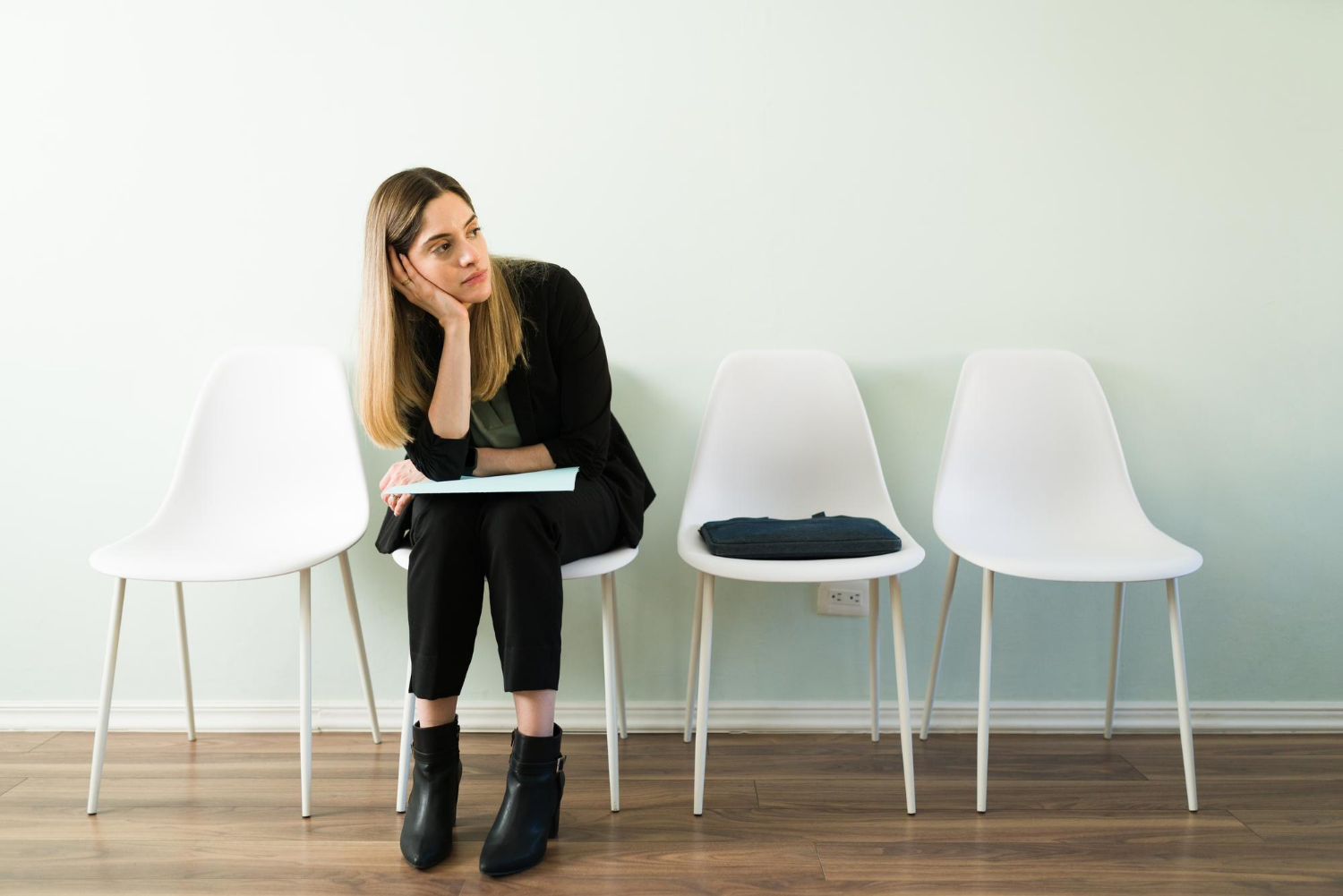 Eine traurige Frau sitzt im Wartebereich | Quelle: Freepik