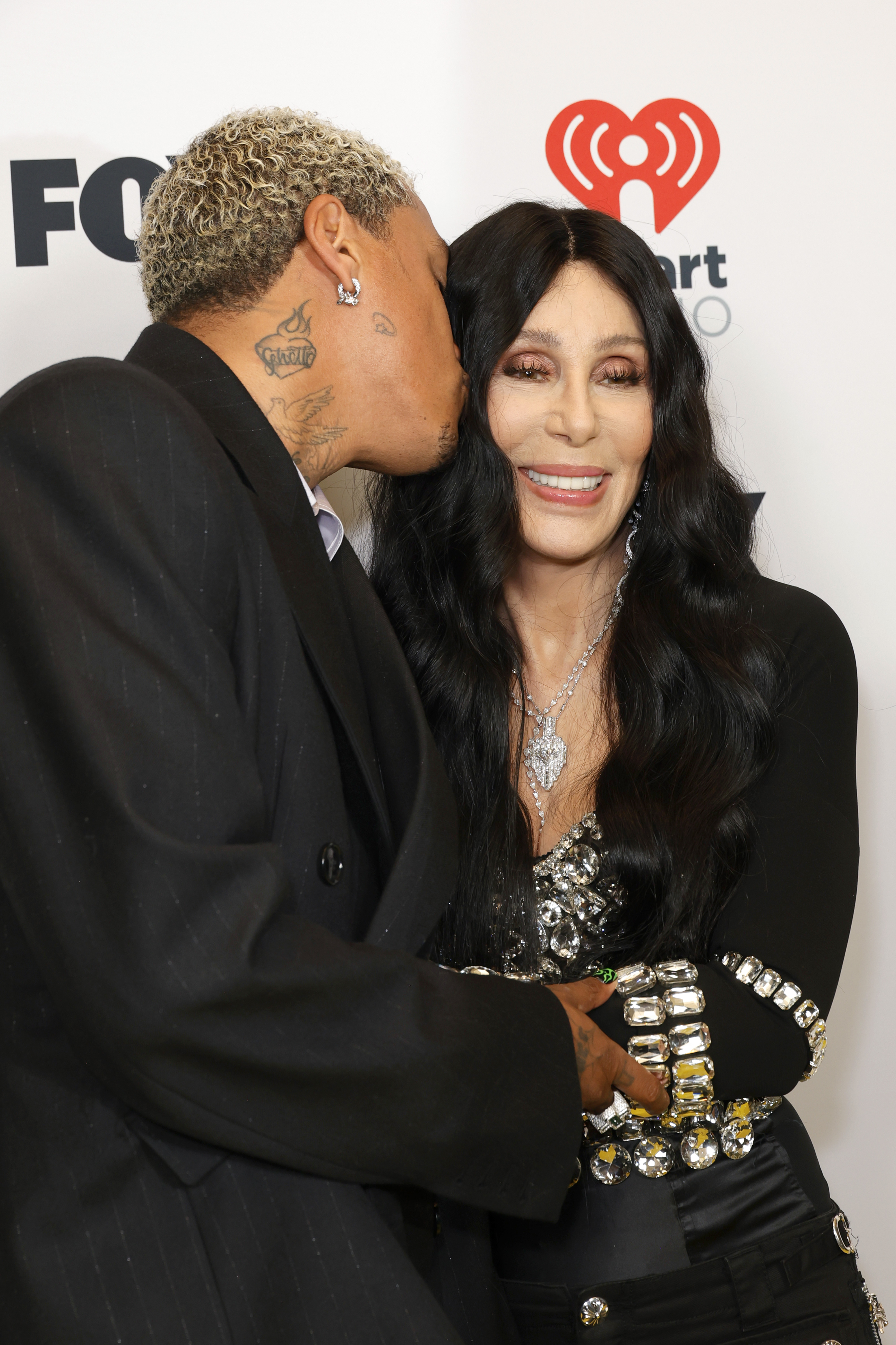 Alexander "AE" Edwards küsst Cher auf die Wange bei den iHeartRadio Music Awards 2024 am 1. April 2024 in Hollywood, Kalifornien. | Quelle: Getty Images