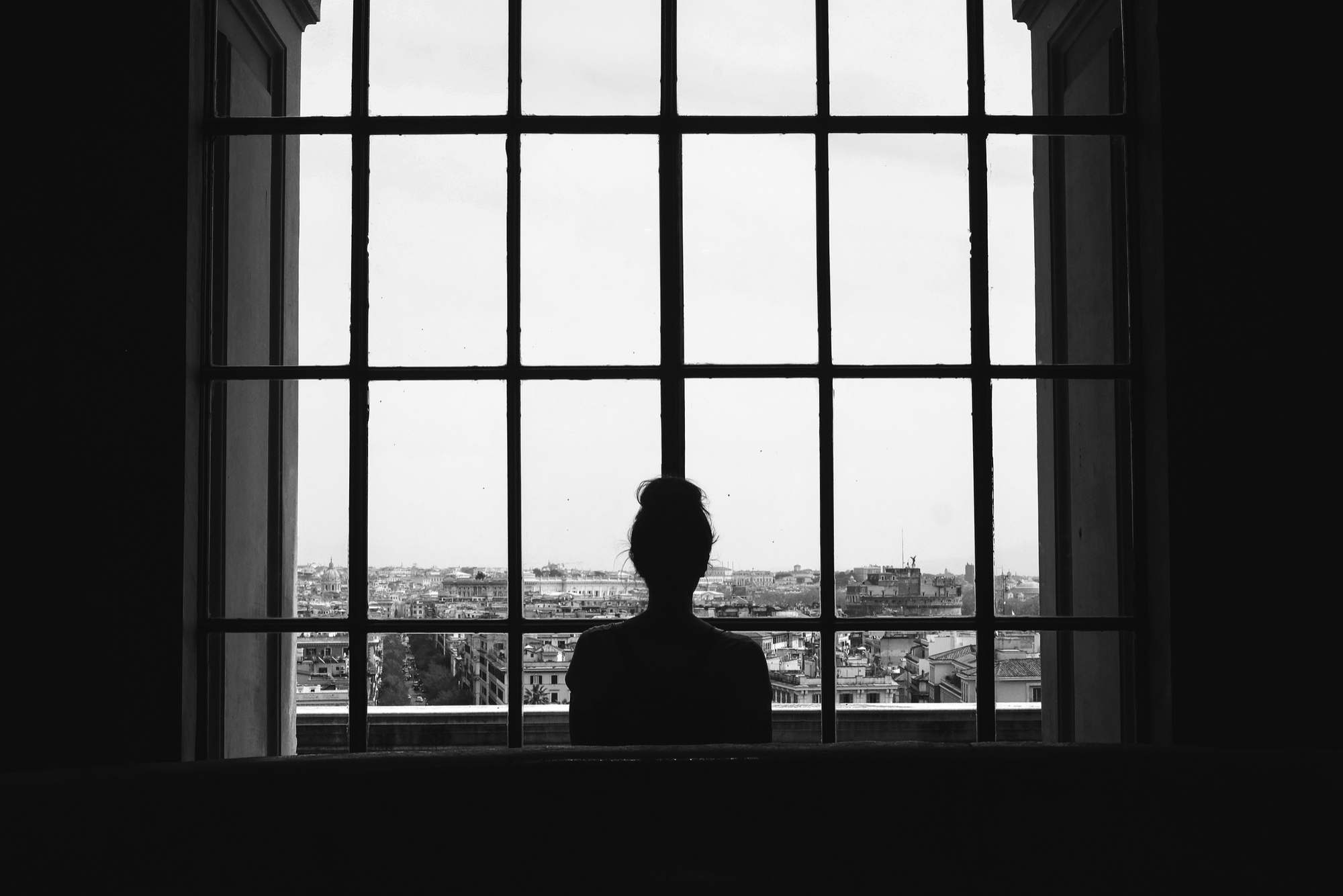 Eine Frau, die an einem Fenster steht | Quelle: Freepik