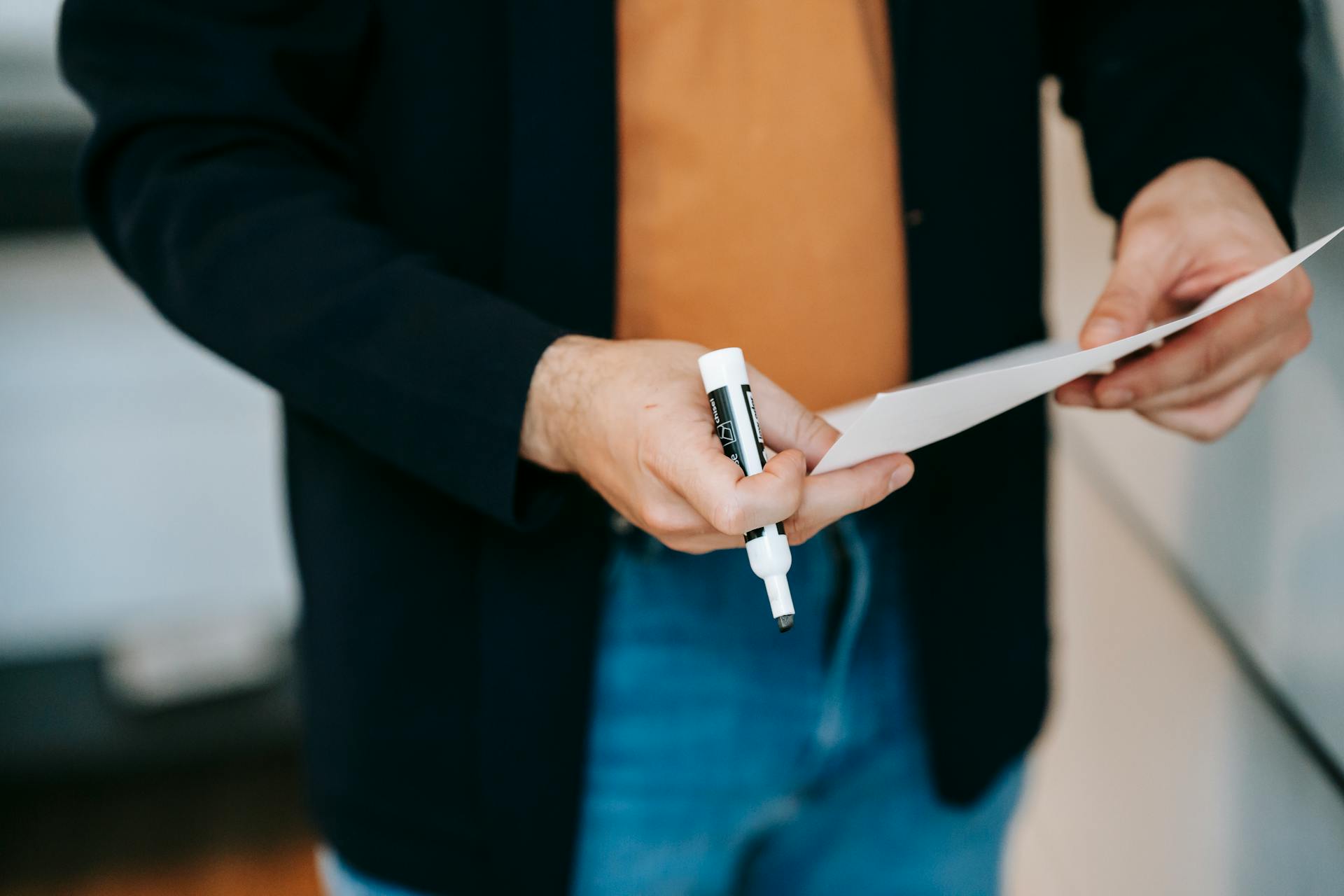 Ein Mann hält einen Marker und ein Stück Papier | Quelle: Pexels