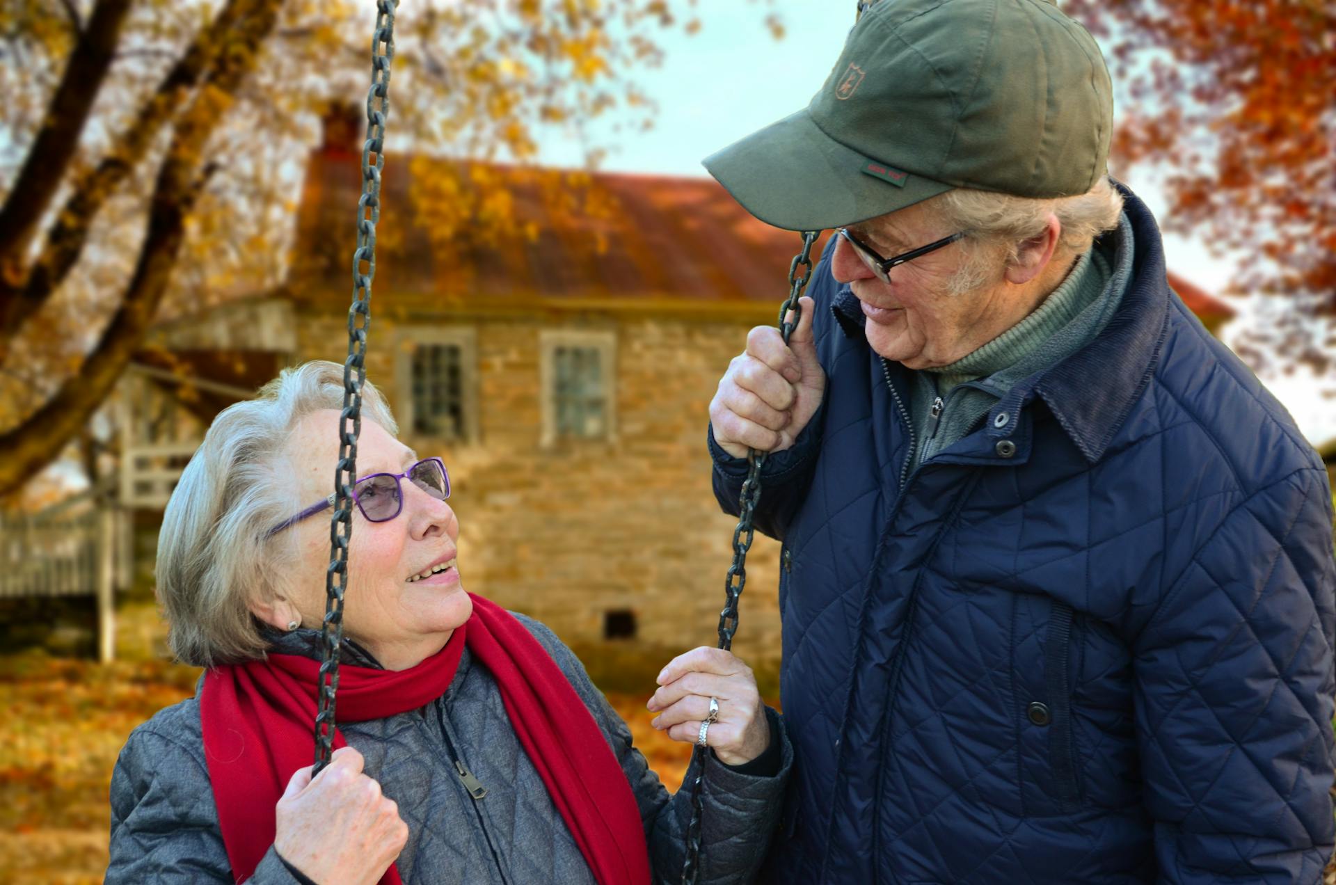 Ein älterer Mann steht neben seiner Frau auf einer Schaukel | Quelle: Pexels