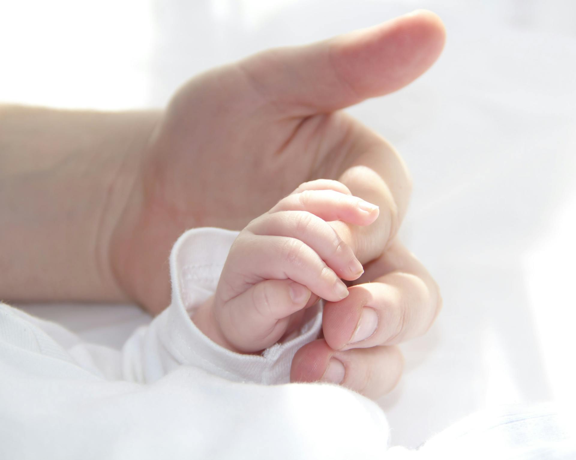 Ein Baby, das den Finger eines Mannes hält | Quelle: Pexels