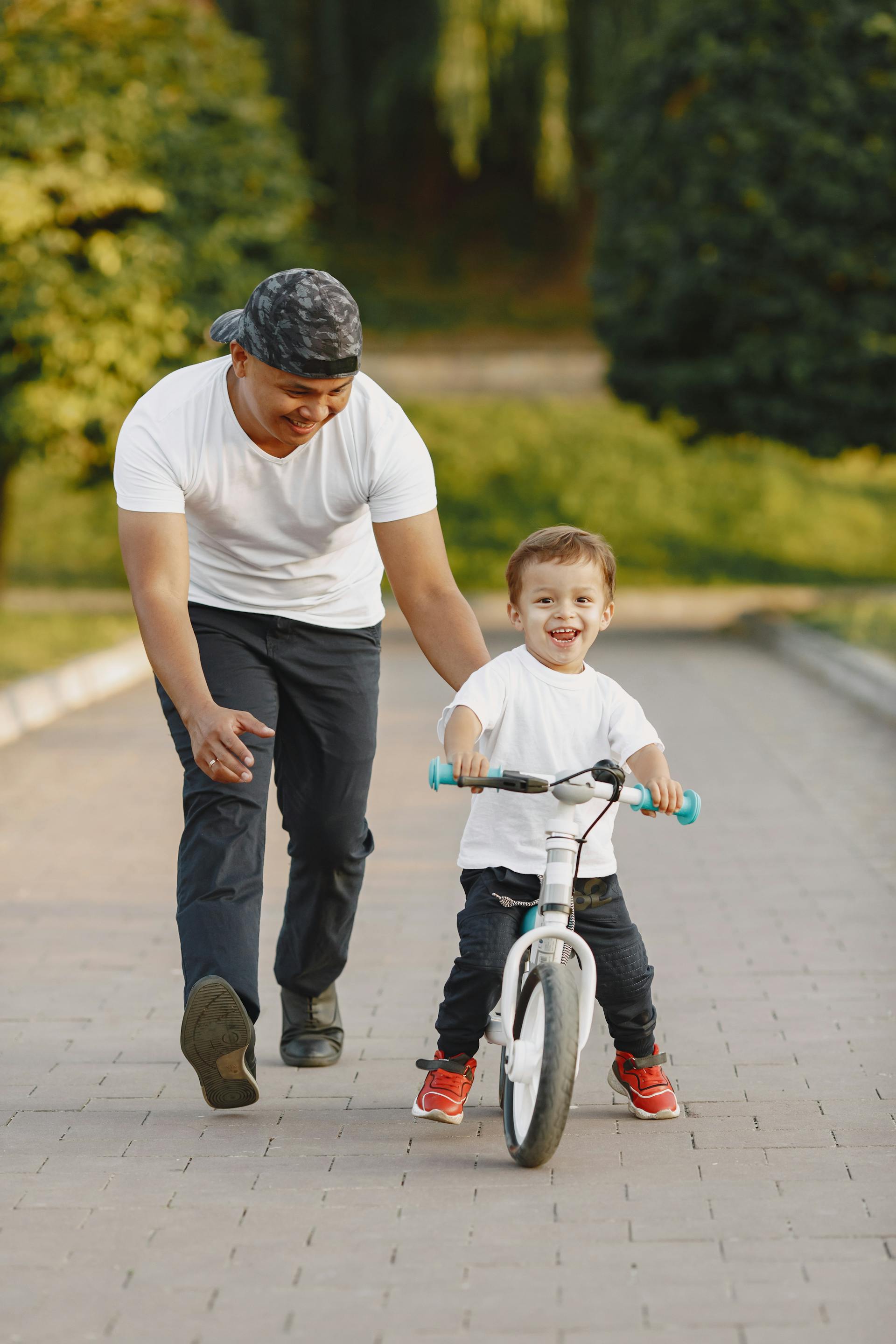 Ein Mann, der seinem Sohn das Fahrradfahren beibringt | Quelle: Pexels