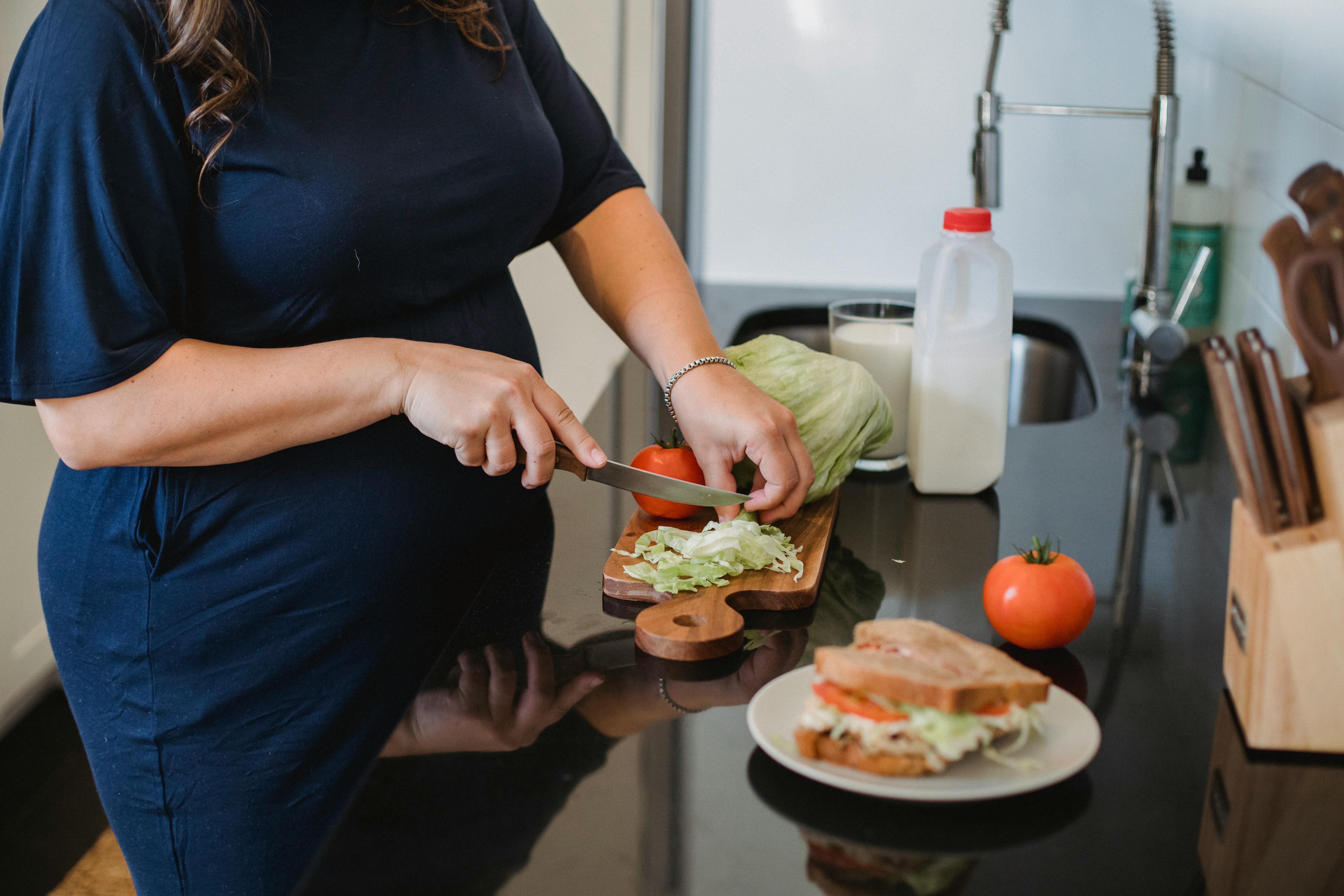 Eine schwangere Frau beim Kochen | Quelle: Pexels