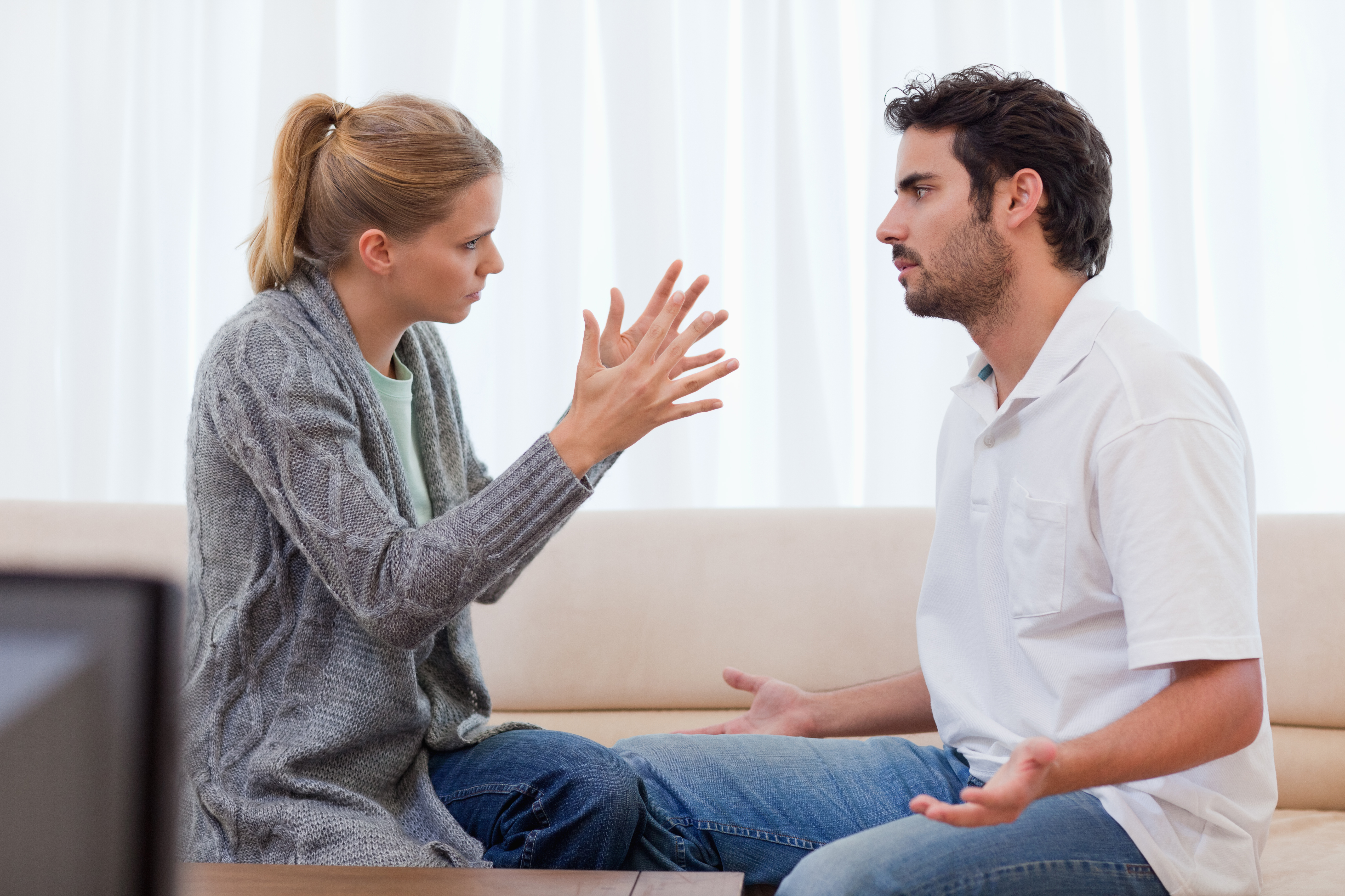 Ein Mann und eine Frau streiten sich im Wohnzimmer | Quelle: Shutterstock