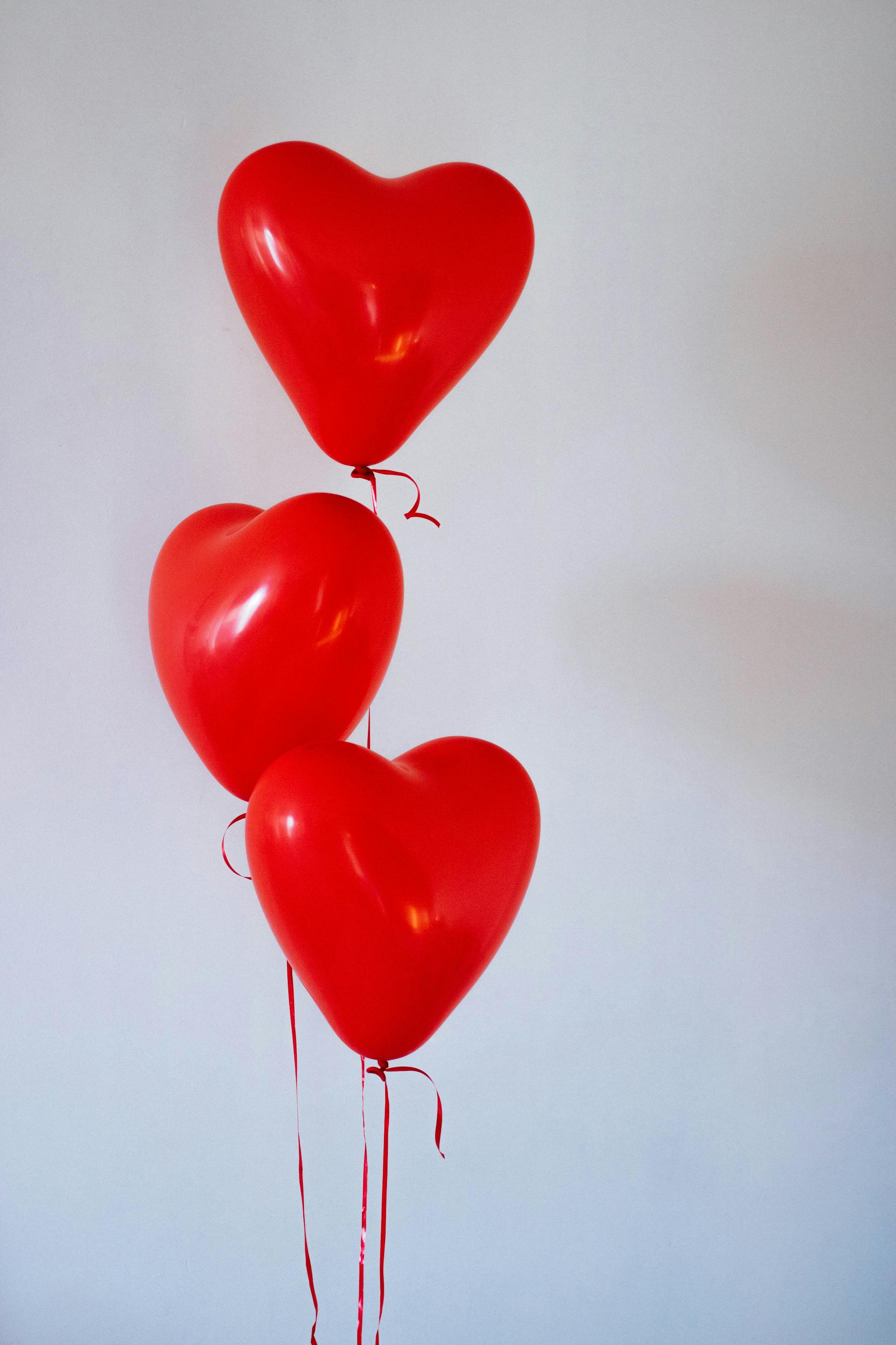 Drei rote herzförmige Luftballons | Quelle: Pexels