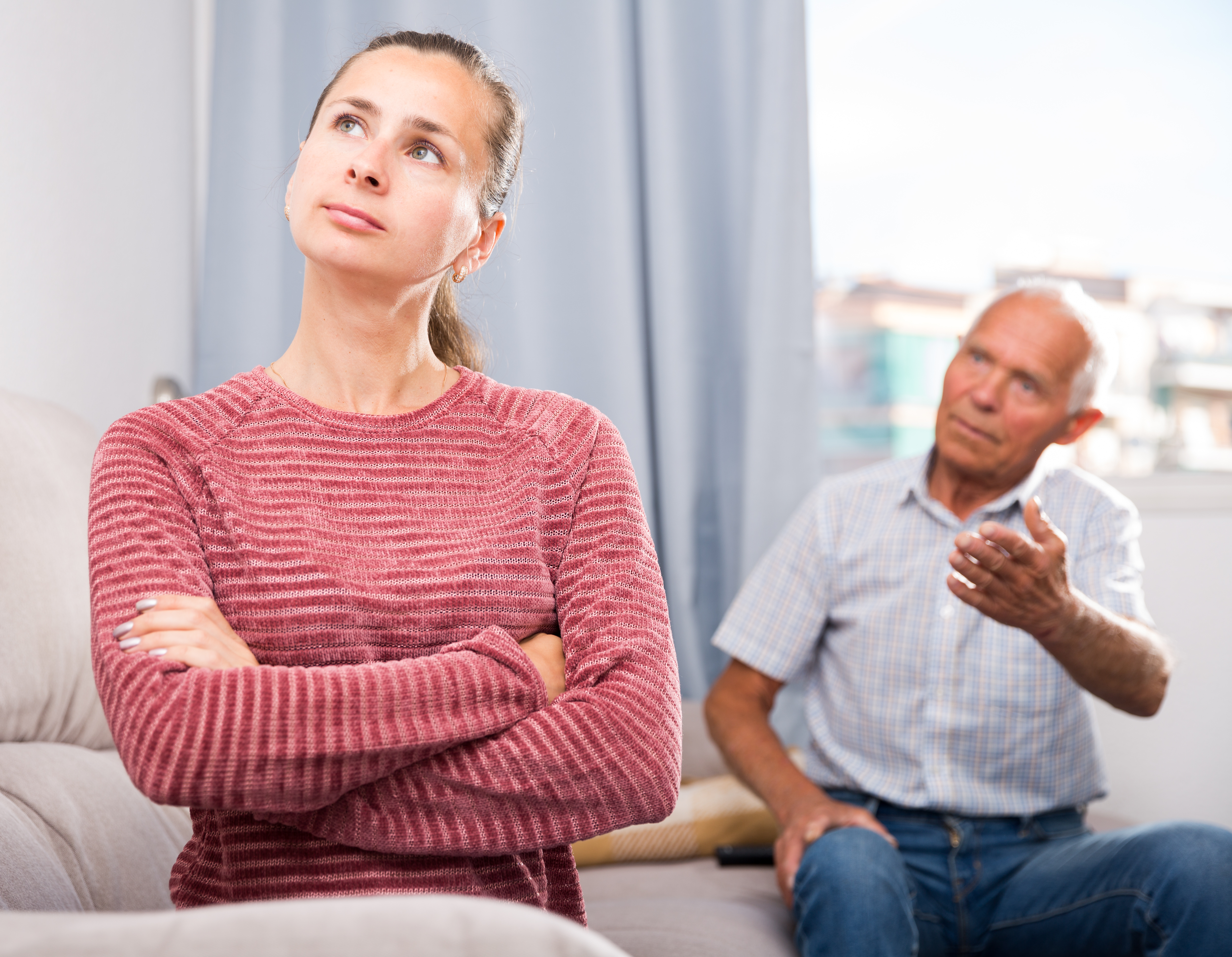 Ein älterer Mann in einer hitzigen Diskussion mit einer jüngeren Frau | Quelle: Shutterstock
