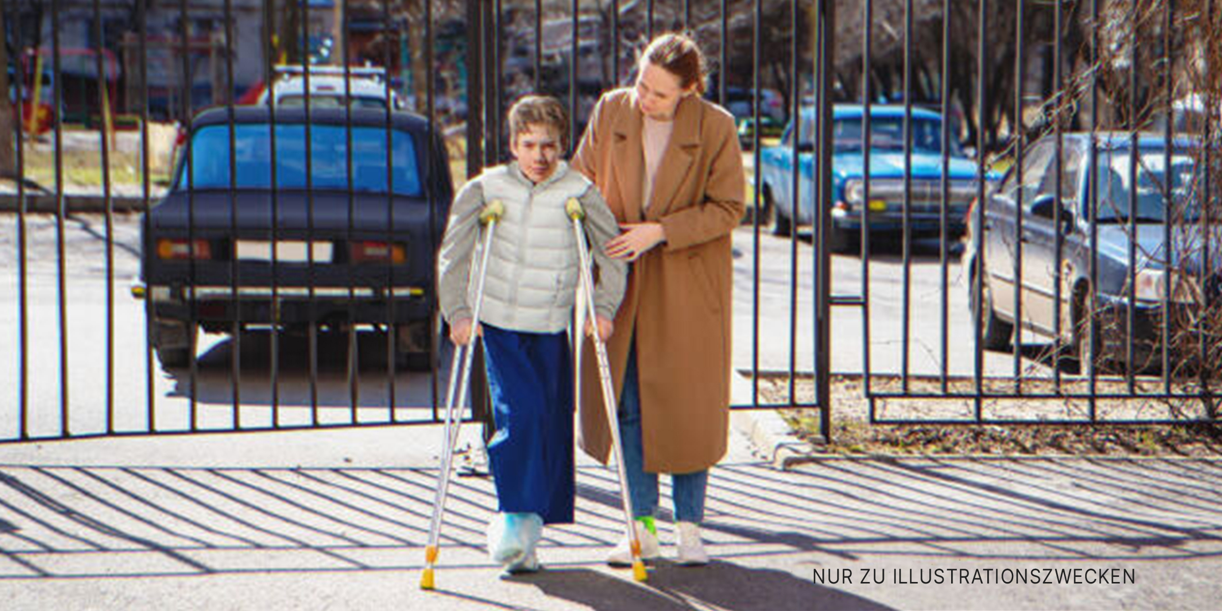 Frau hilft Jungen auf Krücken. | Quelle: Getty Images