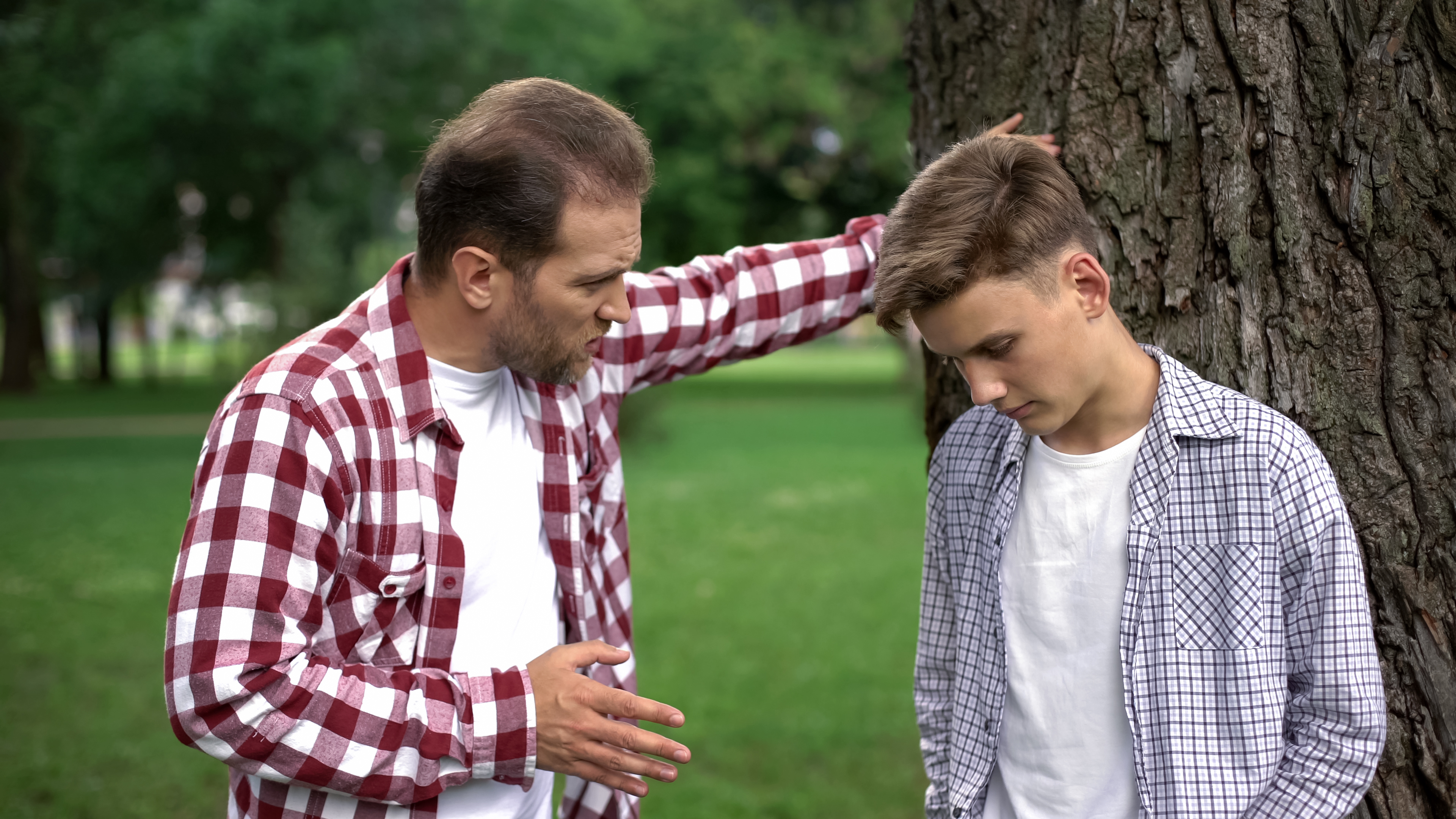 Ein älterer Mann schimpft mit einem jüngeren Mann im Freien | Quelle: Shutterstock