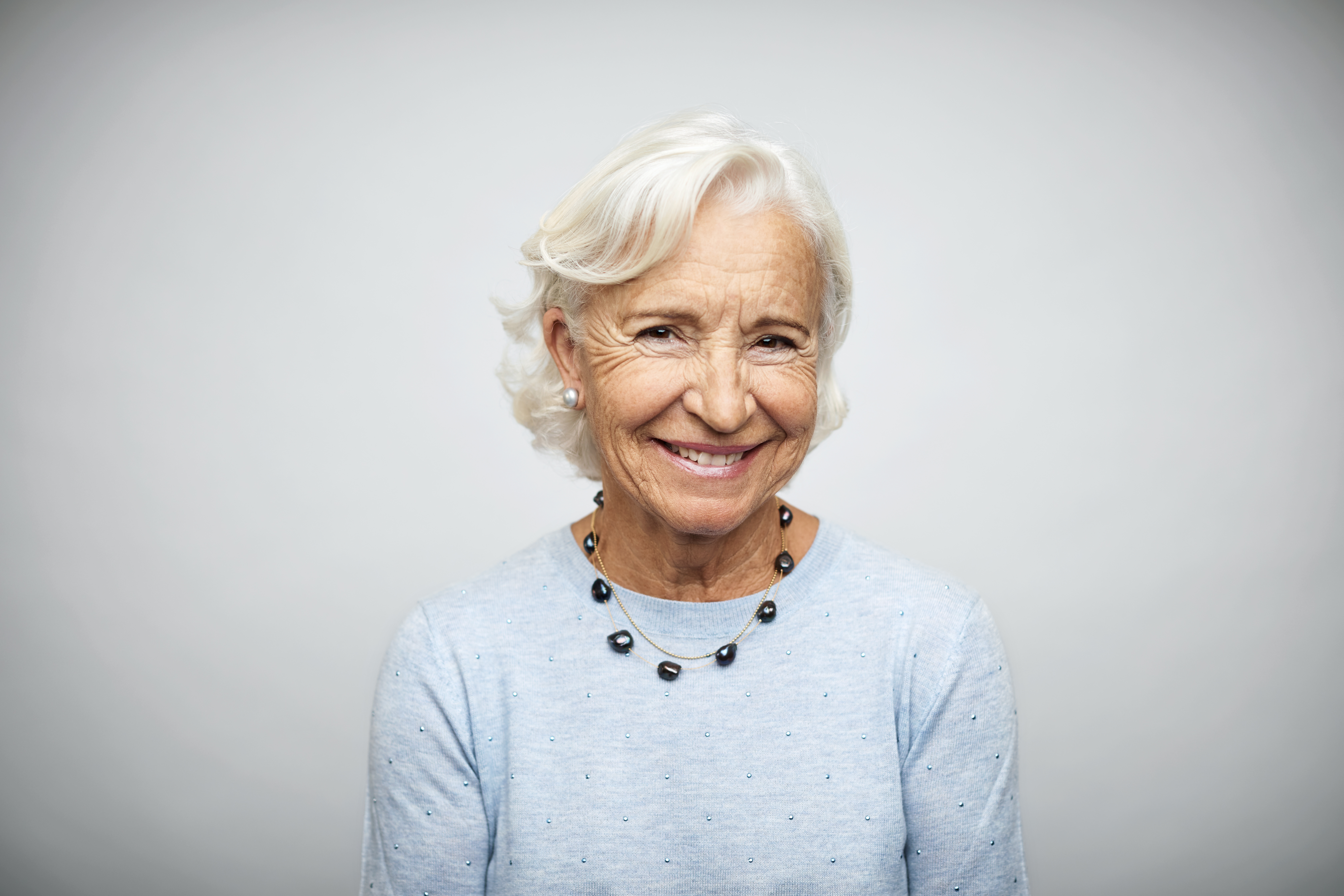 Ältere Geschäftsfrau lächelnd auf weißem Hintergrund | Quelle: Getty Images