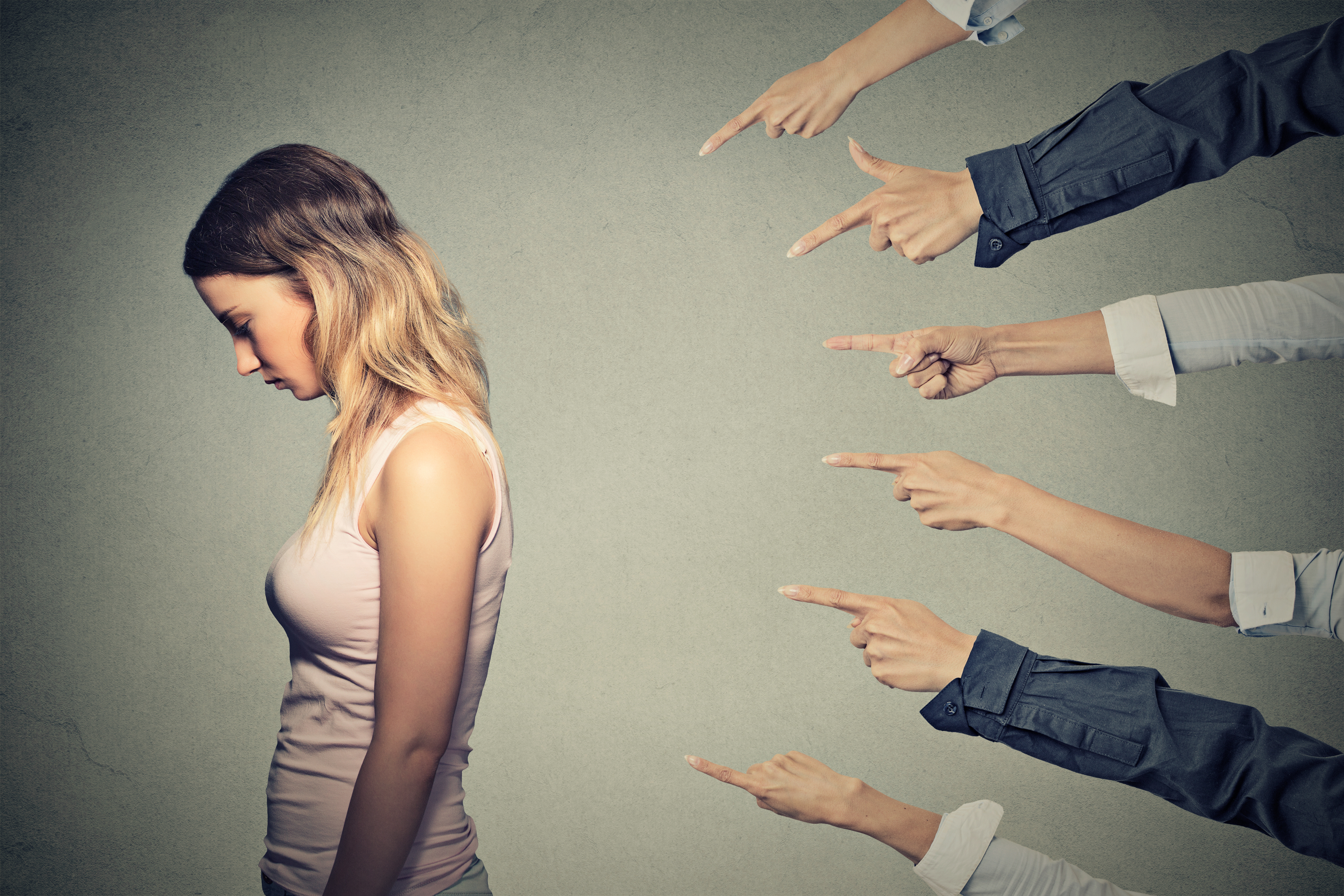 Verärgerte Frau mit vielen Händen, die auf sie zeigen | Quelle: Shutterstock