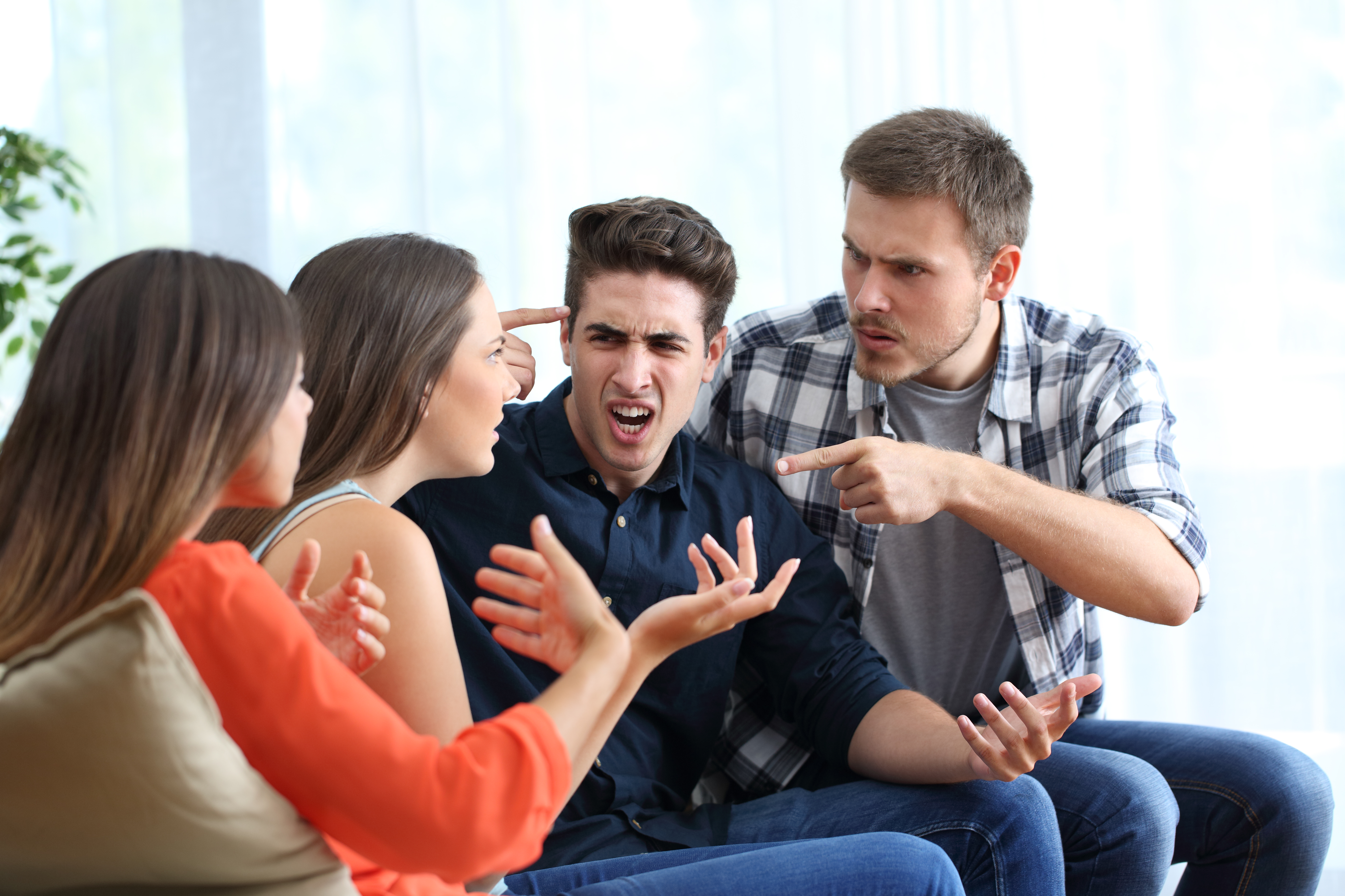 Vier wütende Freunde, die sich zu Hause streiten | Quelle: Getty Images