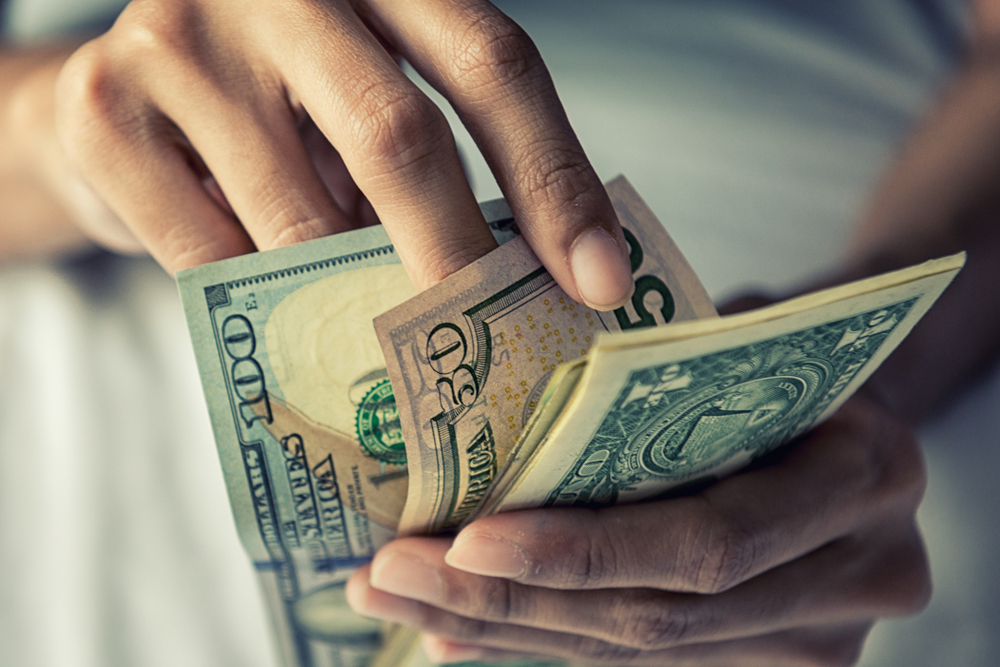Nahaufnahme einer Person mit Geld in der Hand | Quelle: Shutterstock